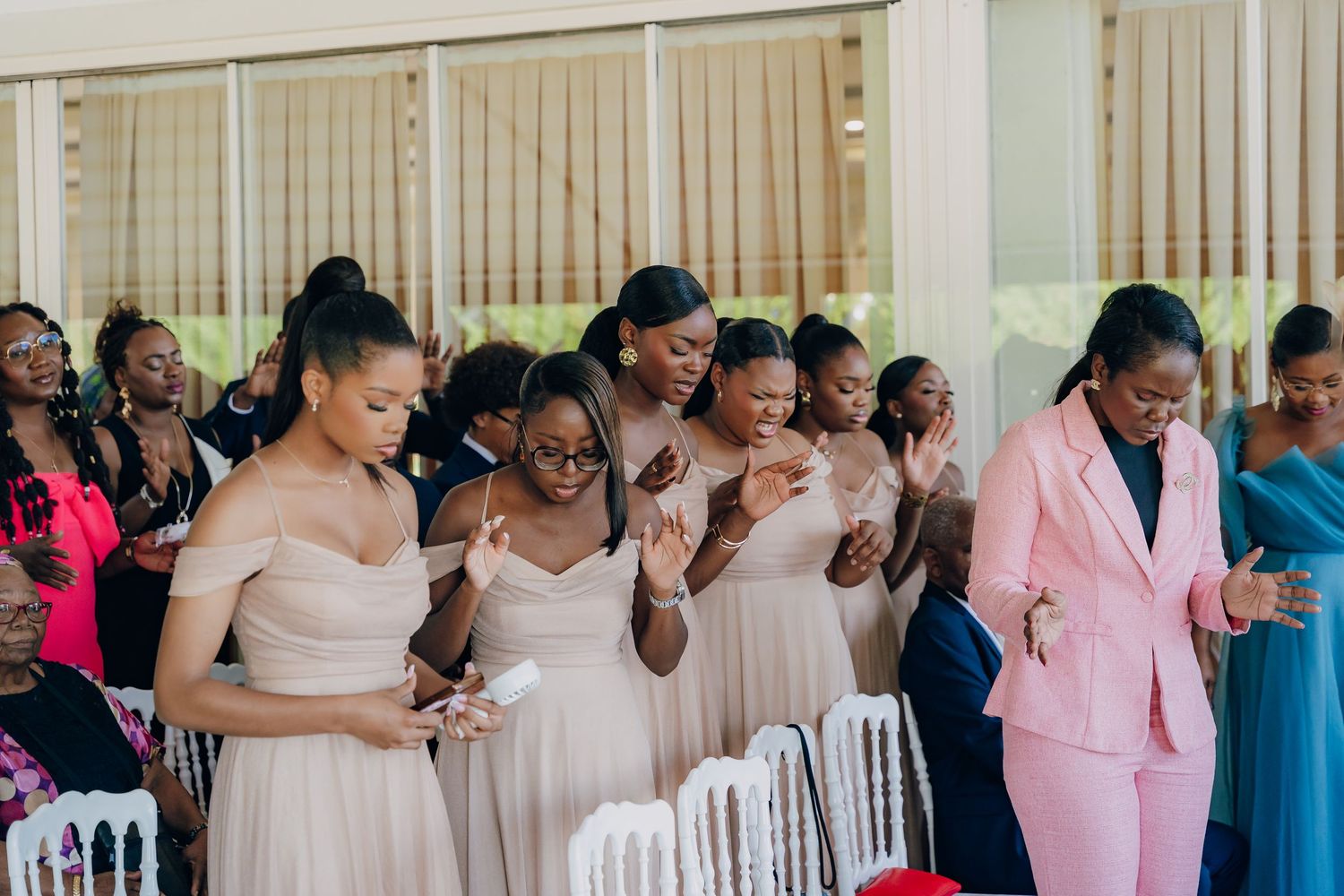 Wedding party members in pastel dresses and formal attire celebrate during an emotional ceremony moment.