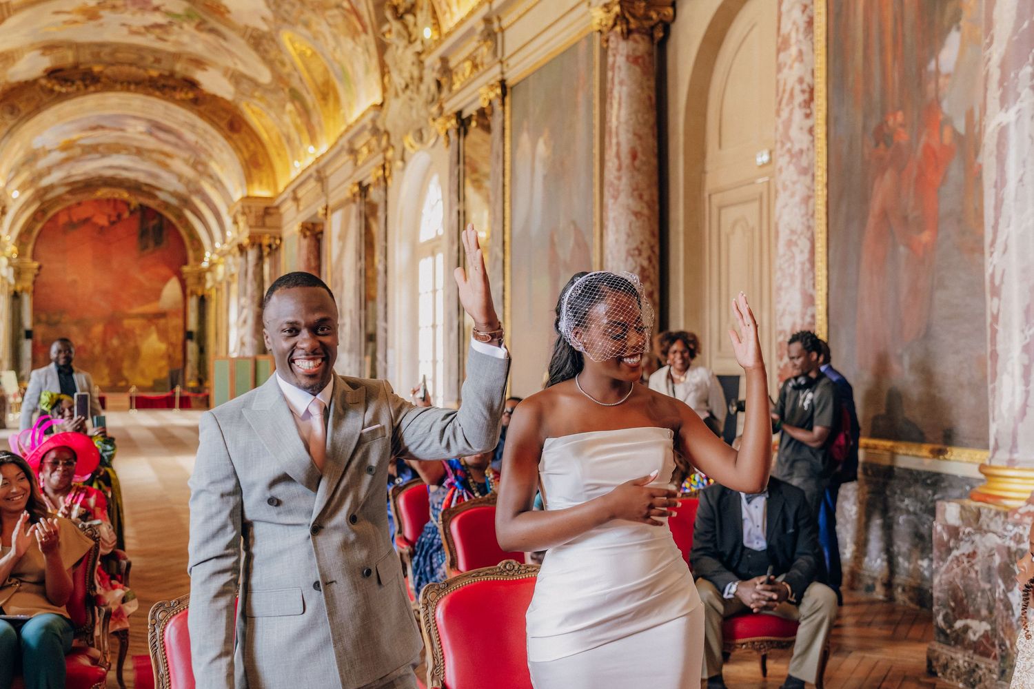 Grand baroque-style hall with gilded details and frescoed ceilings during a formal gathering.