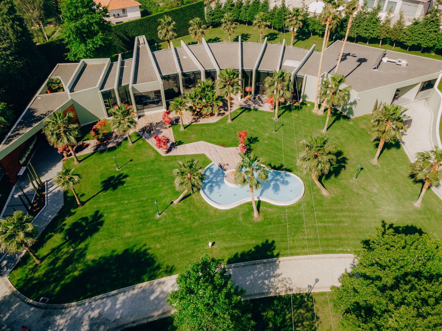 Aerial view of resort property with swimming pool and palm trees.