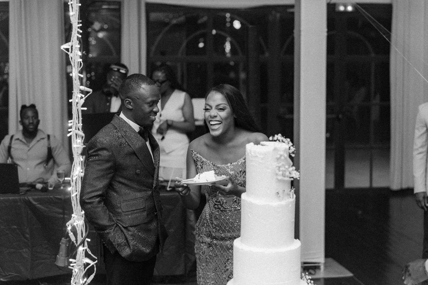 Black and white photo of wedding cake cutting moment with sparklers.