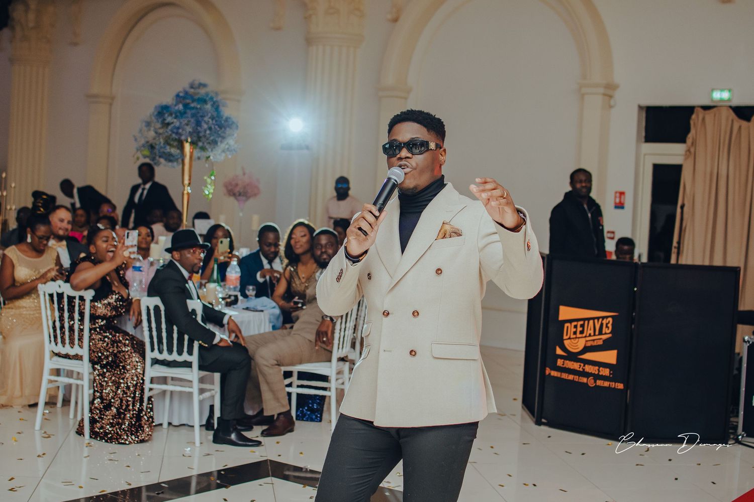 Wedding entertainment performance in cream suit at elegant reception venue.