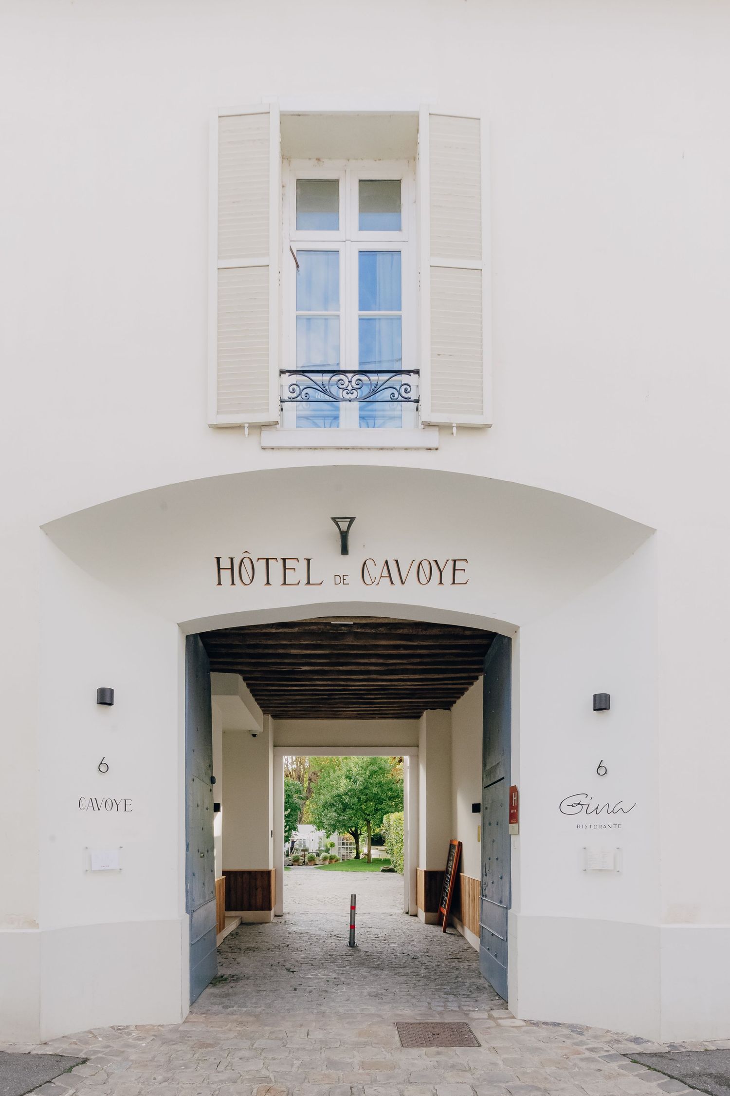 Exterior entrance of Hotel Cavoye with white walls and elegant architectural details.