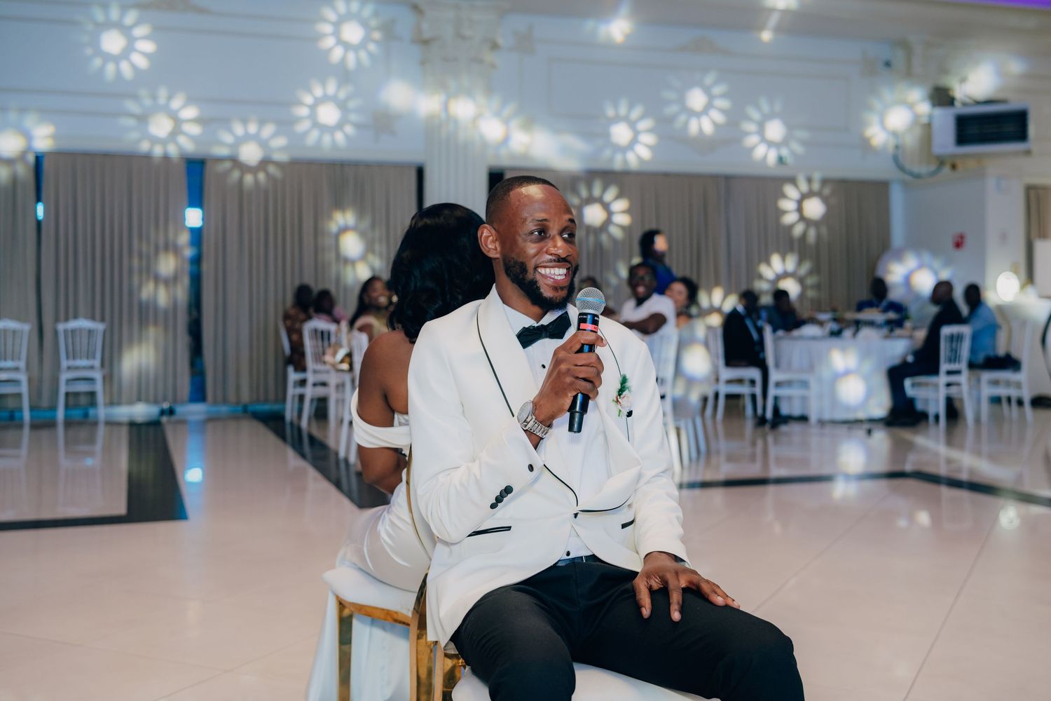 Modern event space decorated with hanging snowflake decorations and white furniture creating a winter wonderland atmosphere.