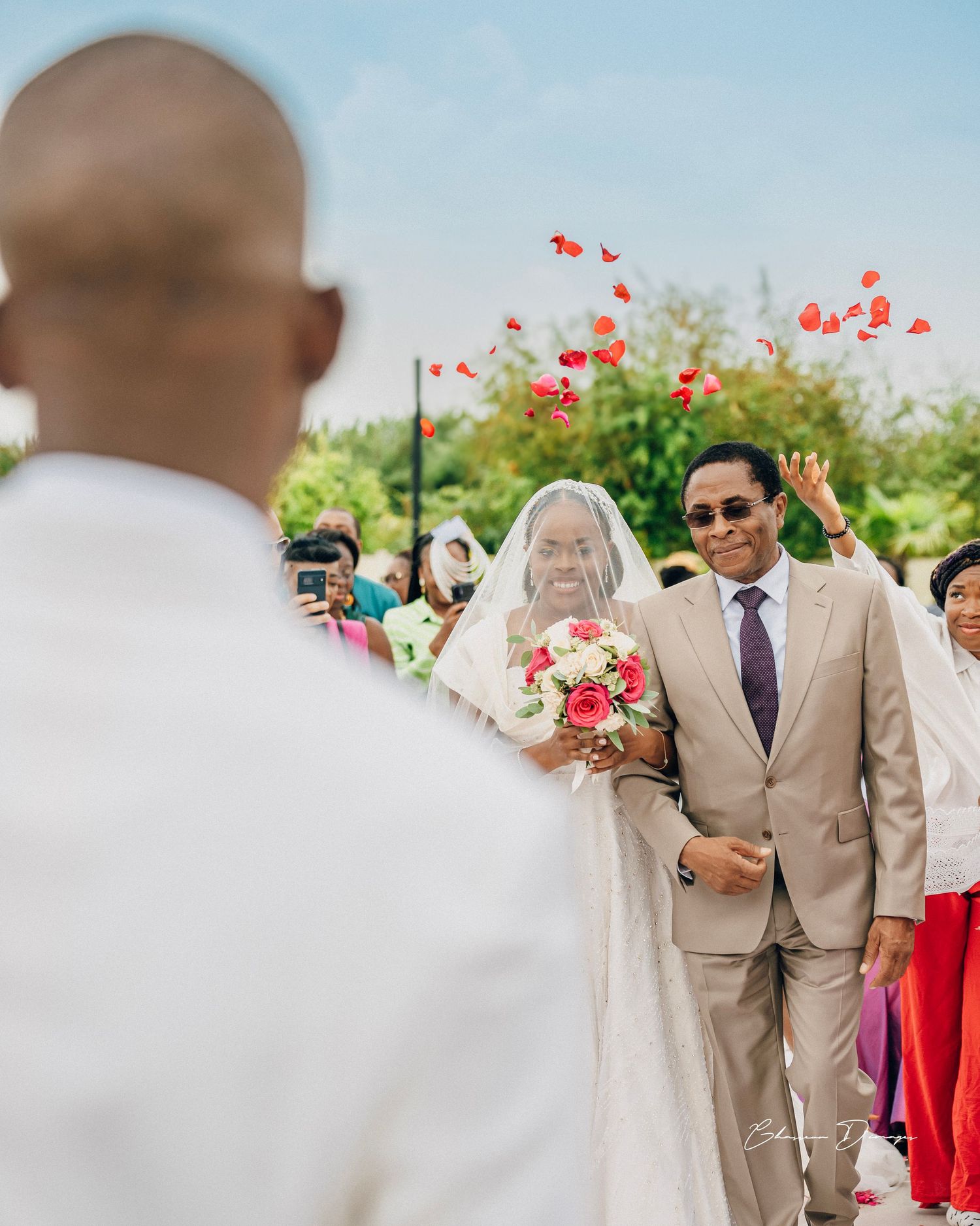 Outdoor wedding ceremony with red balloons floating in the background.