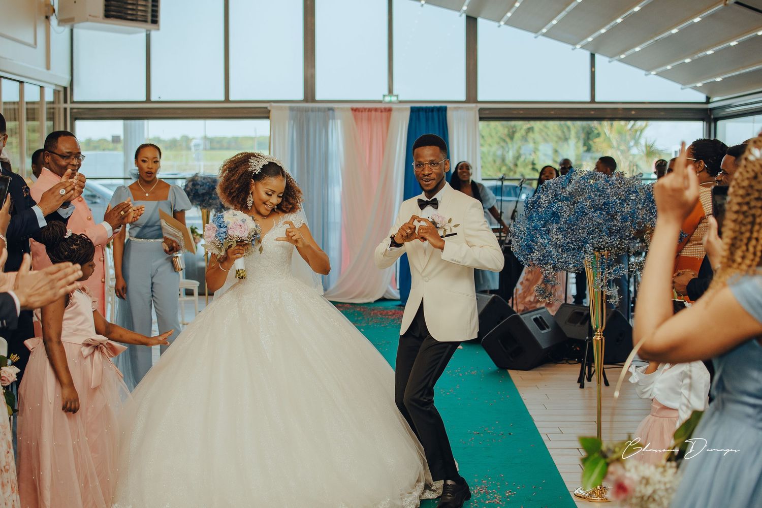 Wedding celebration showing dancing and joy at indoor reception with teal carpet.