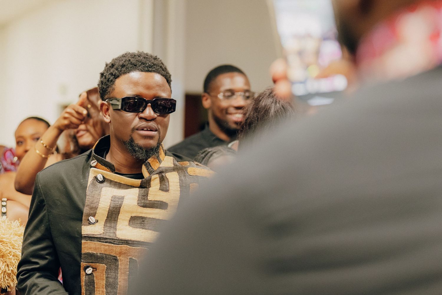 Person wearing sunglasses smiling at social gathering.
