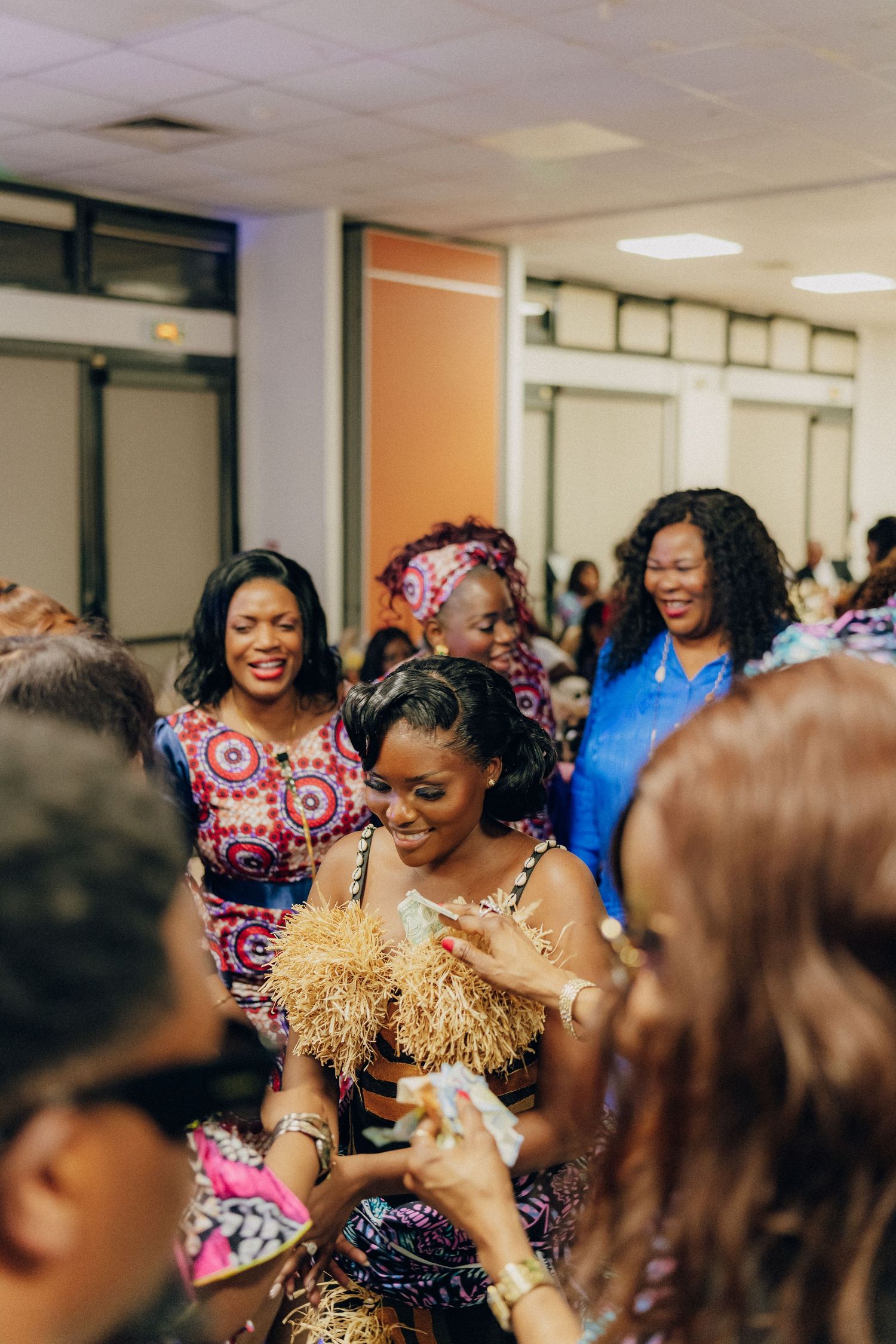 Joyful guests celebrating and taking photos at indoor social gathering.