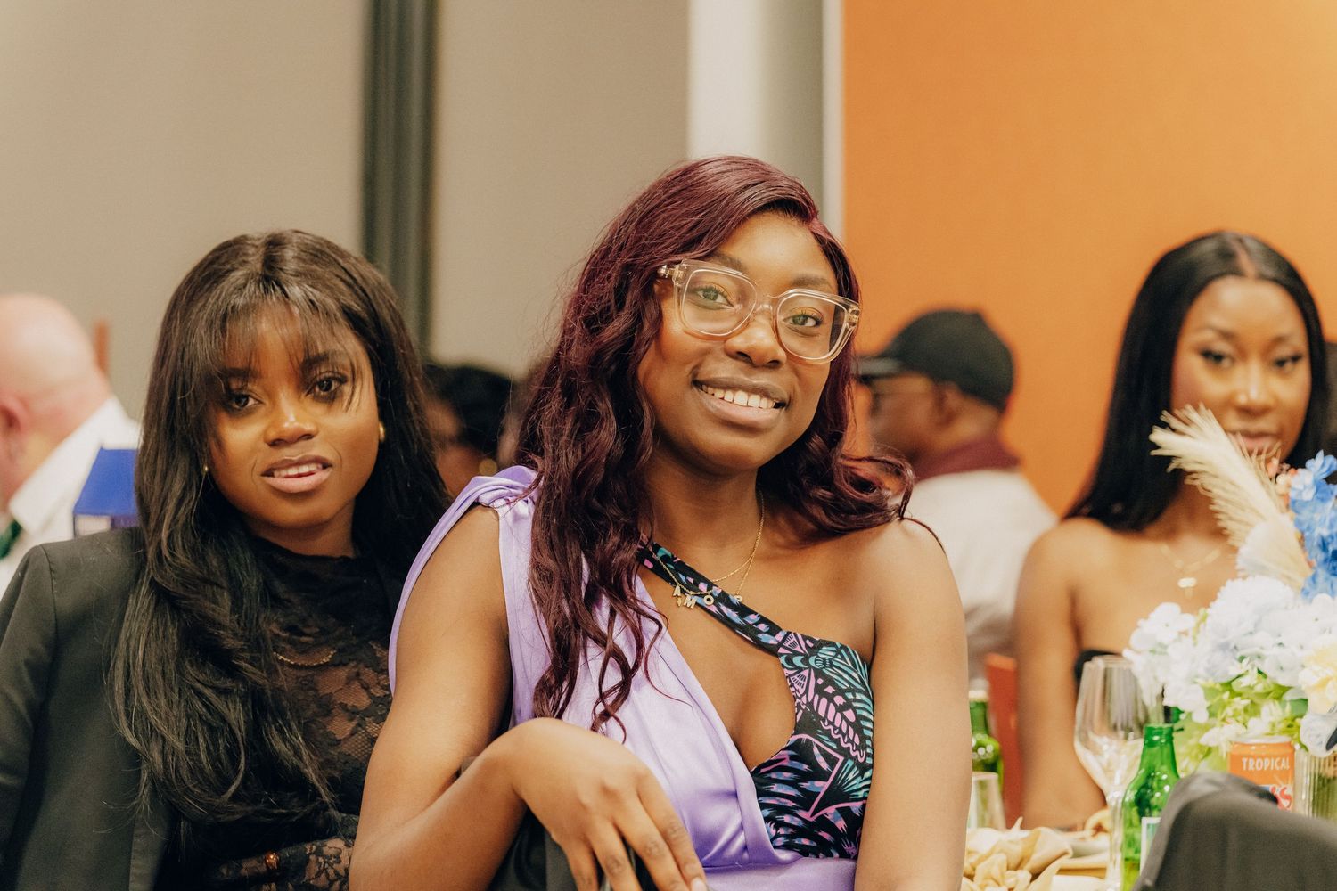 Friends enjoying a celebratory moment at a social gathering with festive smiles and elegant attire.