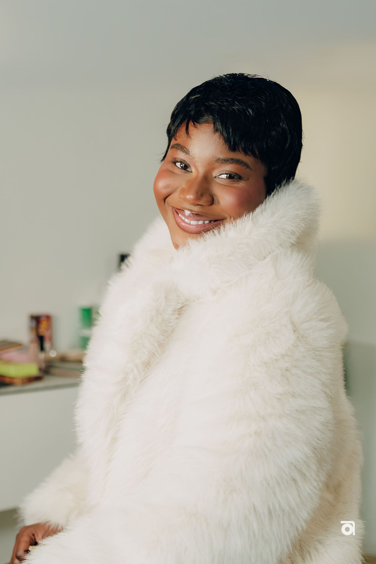 Person wearing a plush white faux fur coat in an indoor setting.
