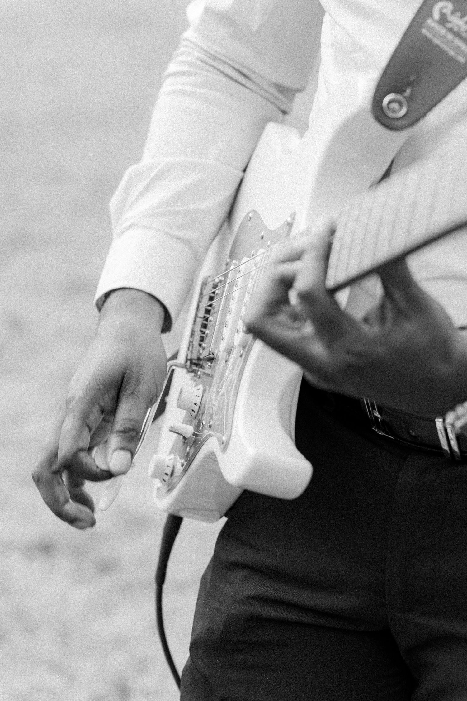 Close-up detail of hands holding a white fabric or garment during a formal occasion.