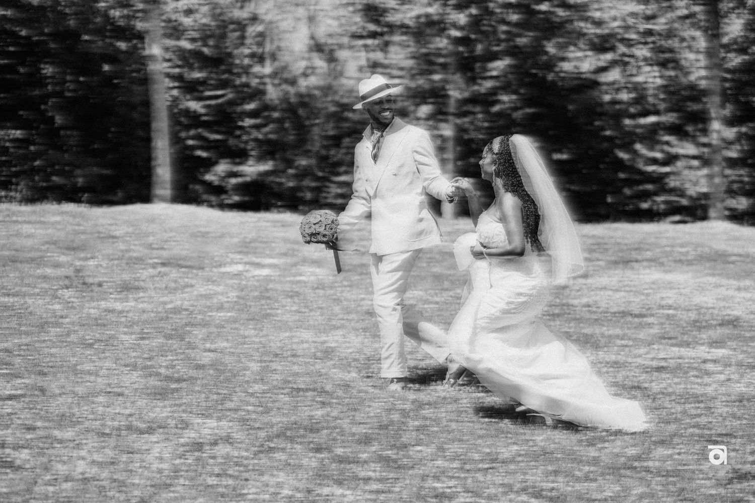 A black and white photo captures a couple in a garden setting during what appears to be a wedding ceremony.