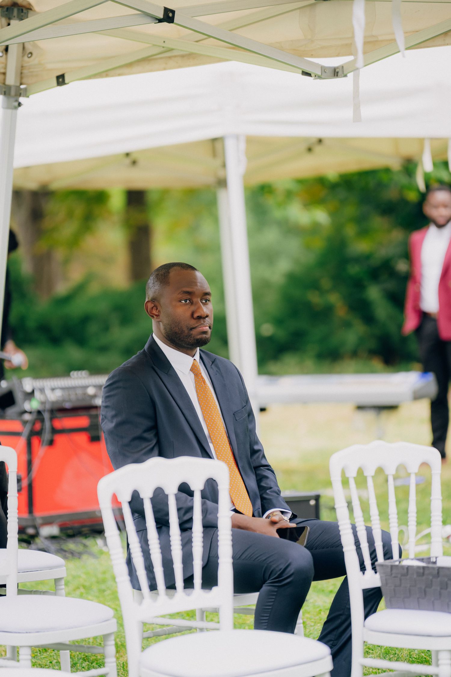 White chairs arranged under a white tent canopy at an outdoor event venue.