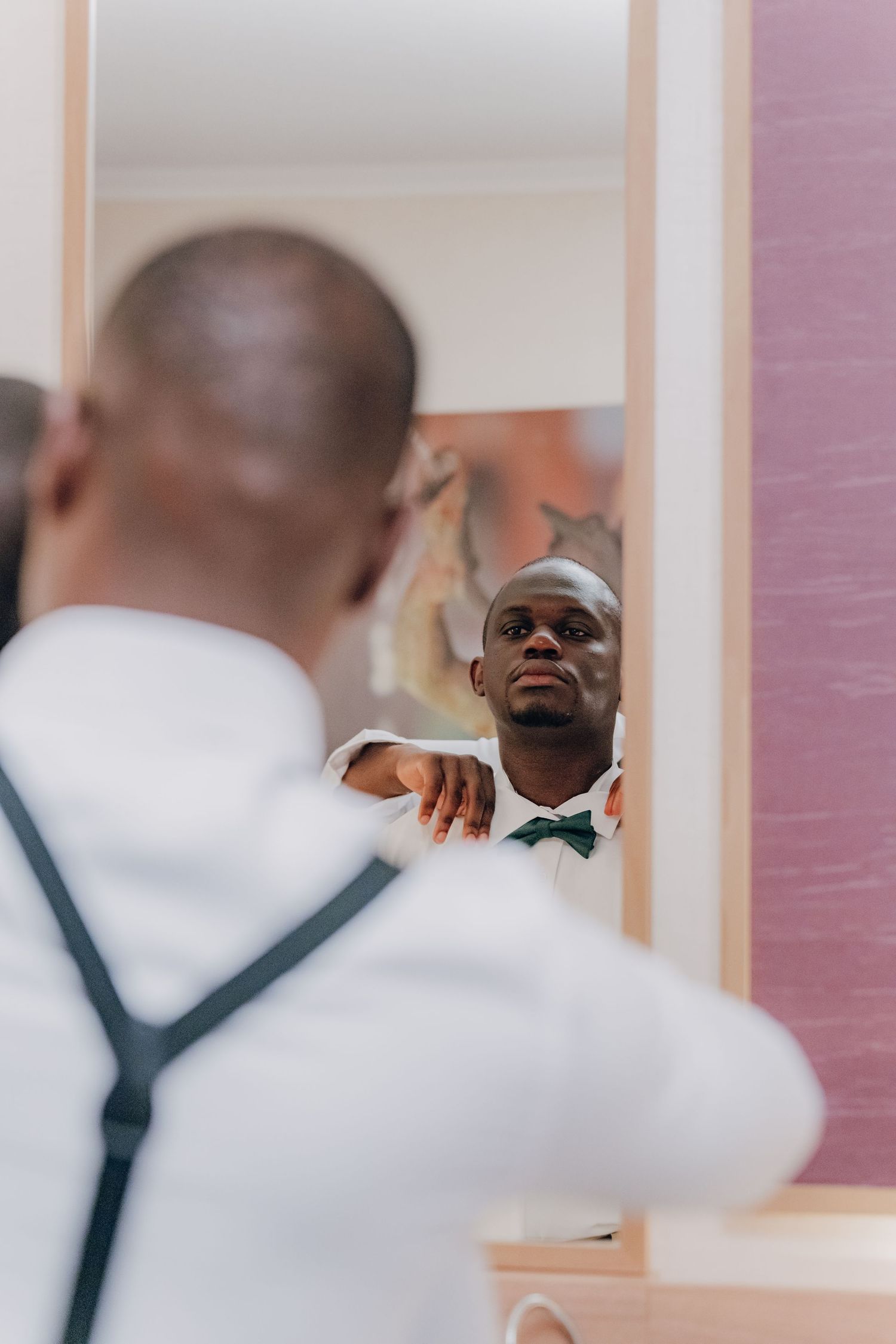 A series of mirror reflections shows a person in a white shirt laughing joyfully while looking at their reflection.