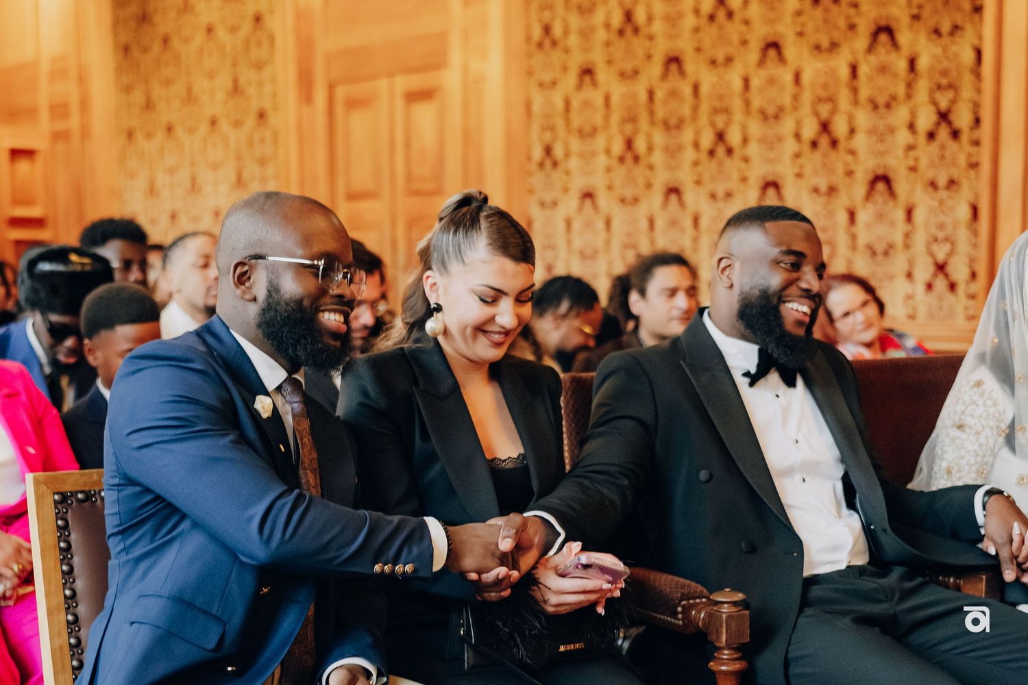 Guests enjoying themselves and sharing laughter during an elegant wedding reception in a decorative venue.