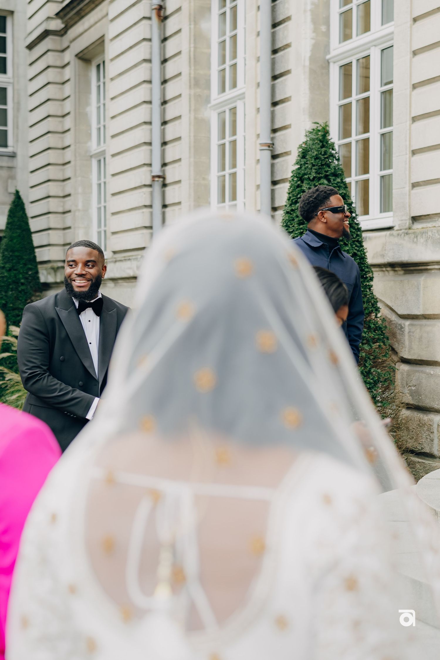 A joyful moment captured during a wedding celebration outside a grand European building.