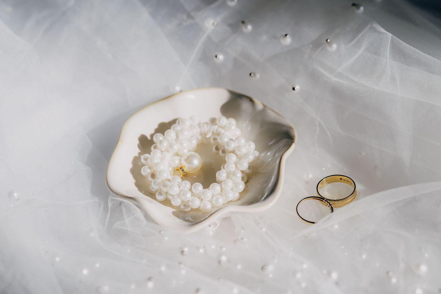 A collection of geode crystal rings displayed on a white surface with scattered sparkly gems and crystals.