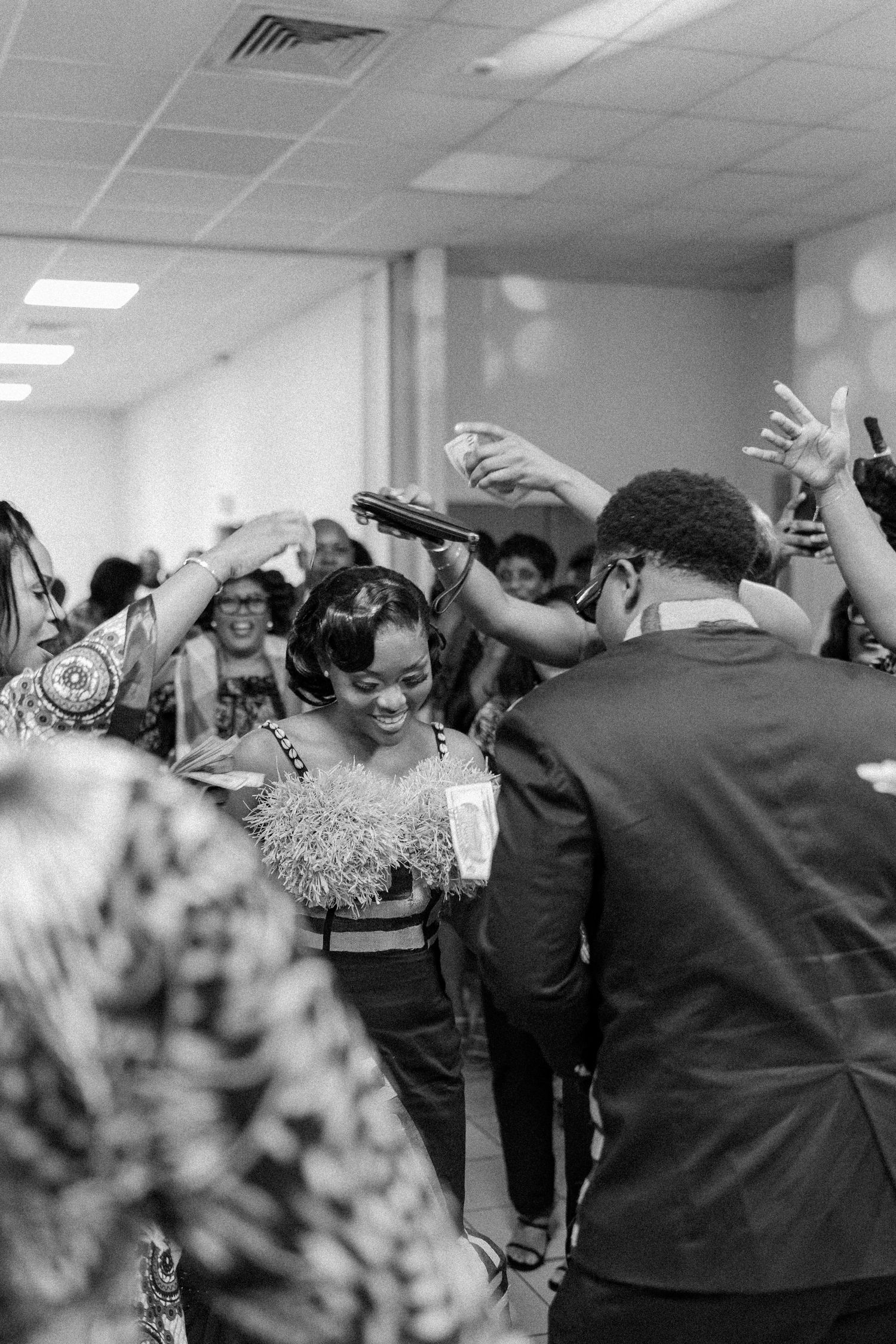 Crowd of people dancing and celebrating at indoor party.