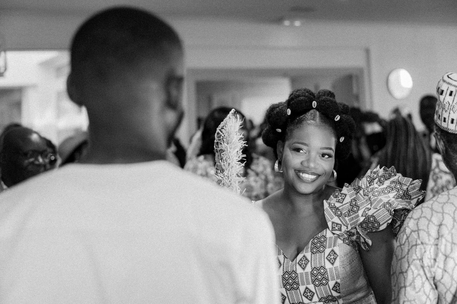 Black and white candid photo of a celebration with people gathered indoors.