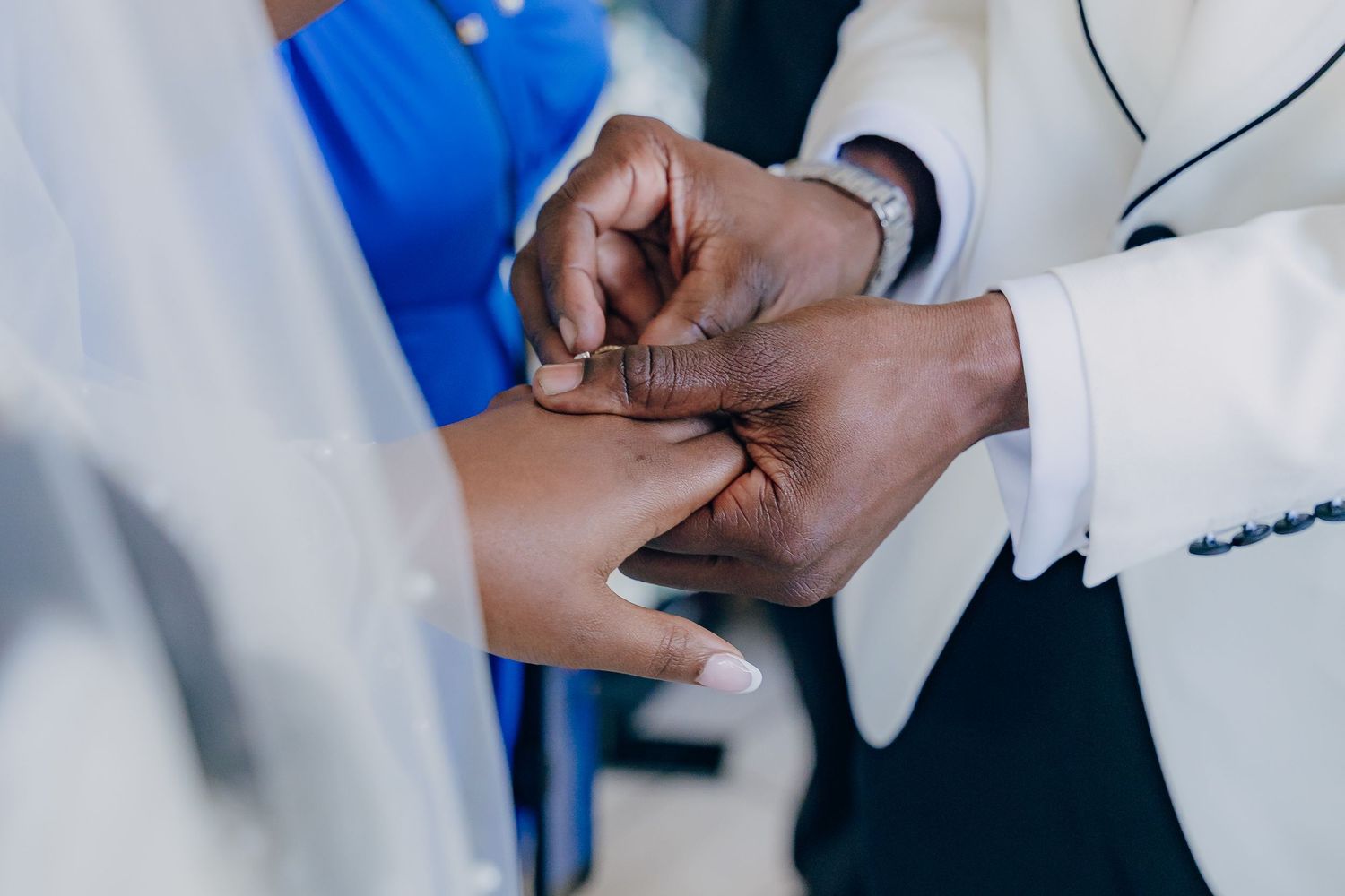 Medical professional in white coat examines patient's hand during healthcare consultation.
