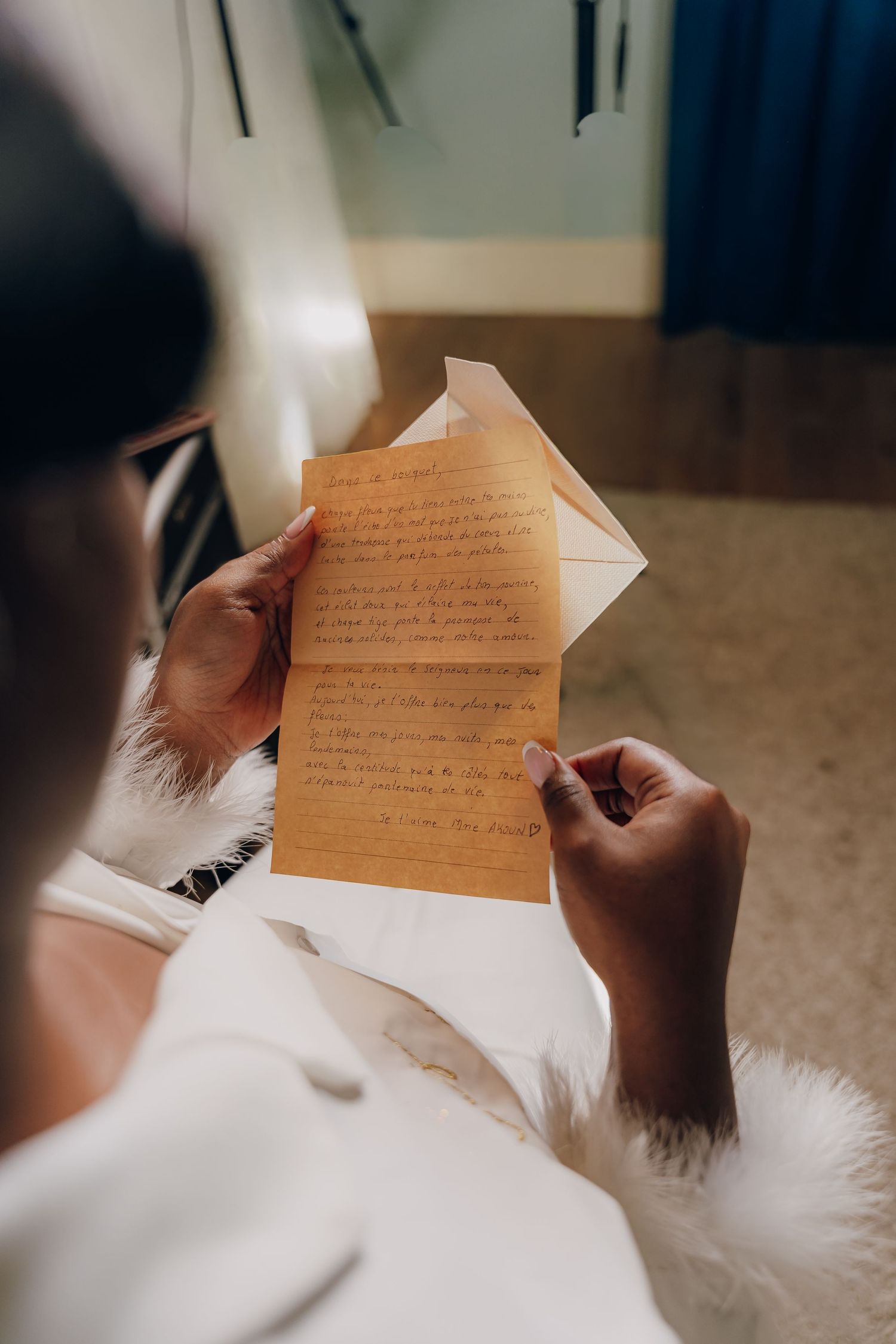 Hands holding and writing on a handwritten note in warm lighting.