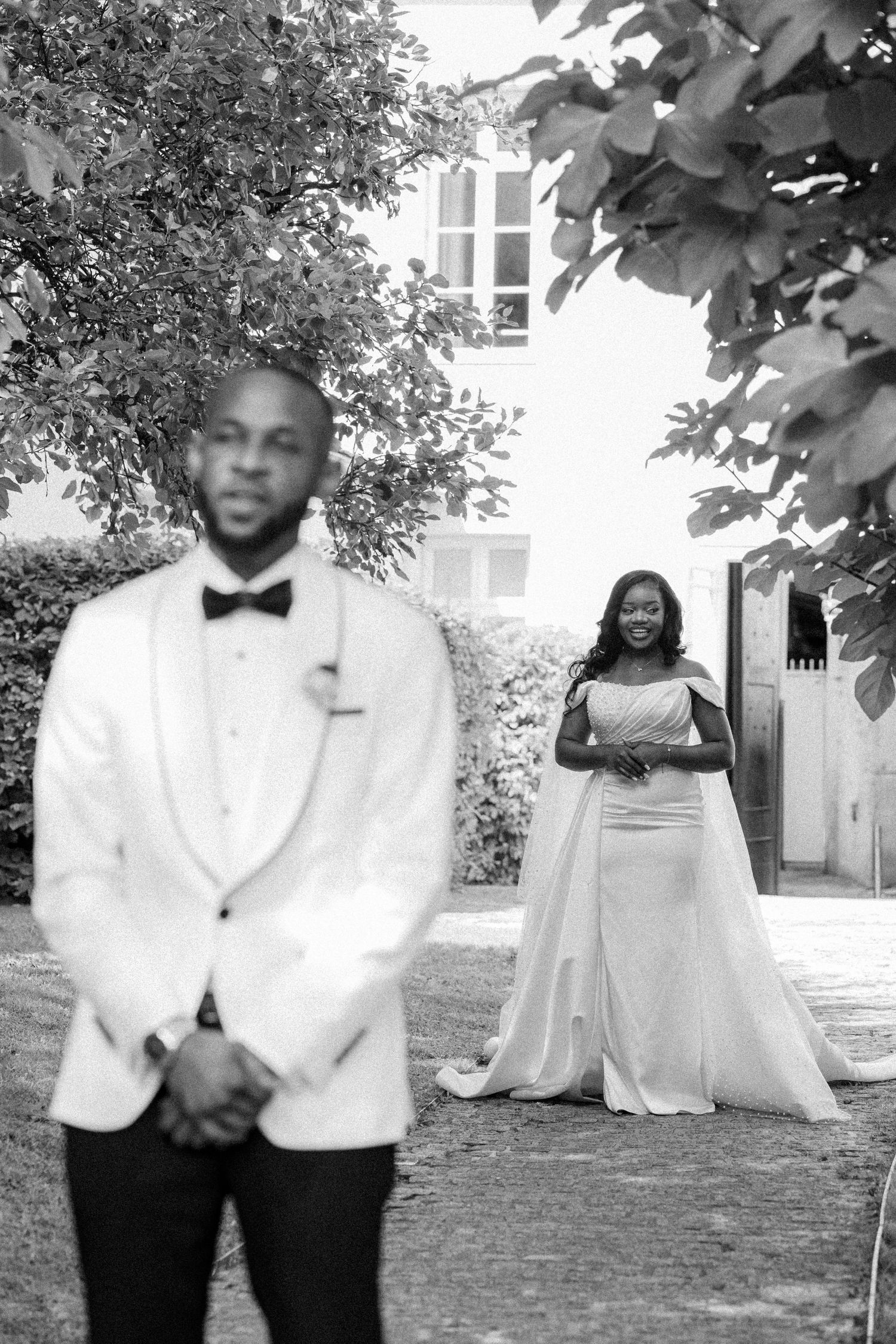 A series of black and white wedding photos showing a couple posing outdoors under trees.