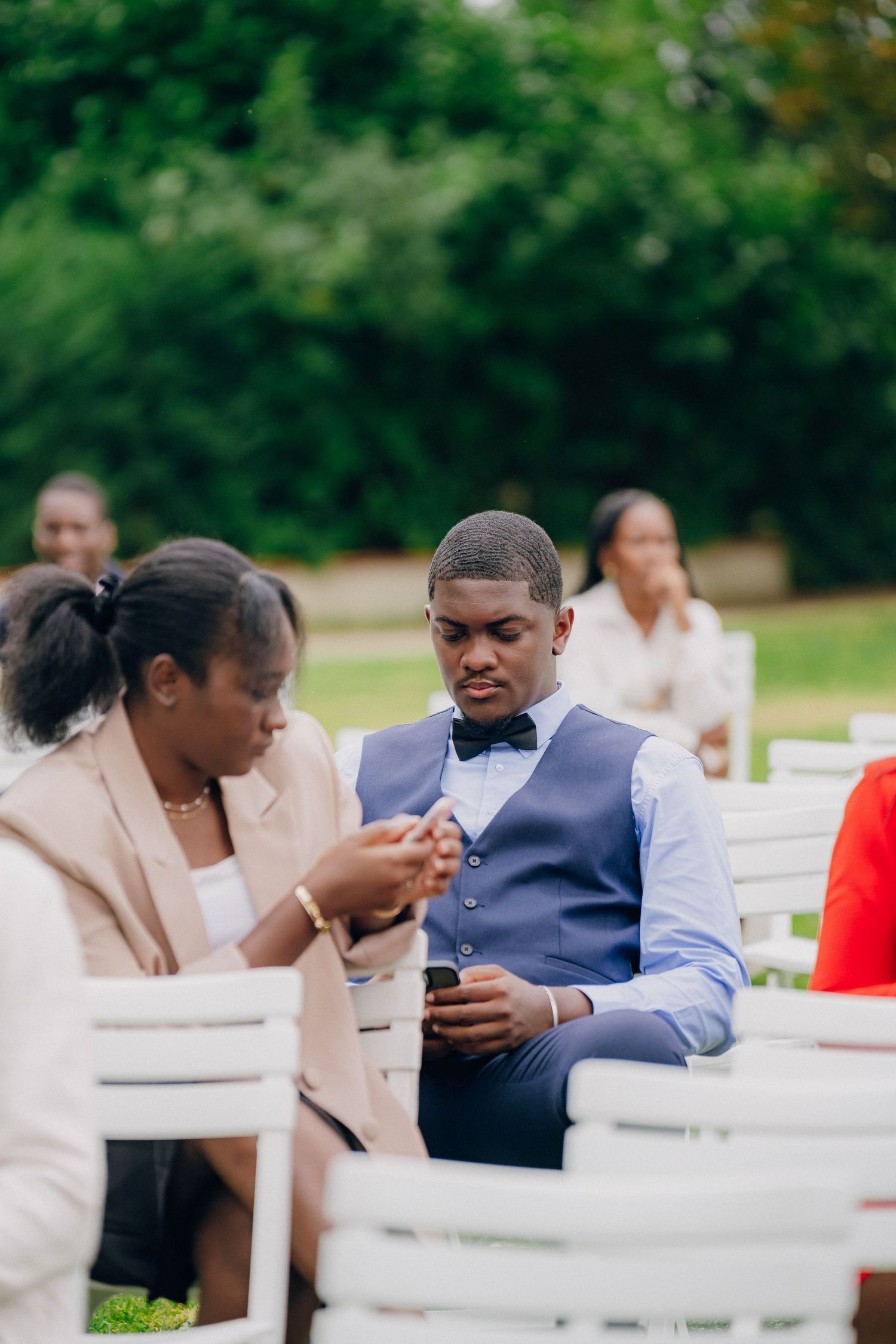 Wedding guests seated at outdoor tables enjoying conversation during a reception.