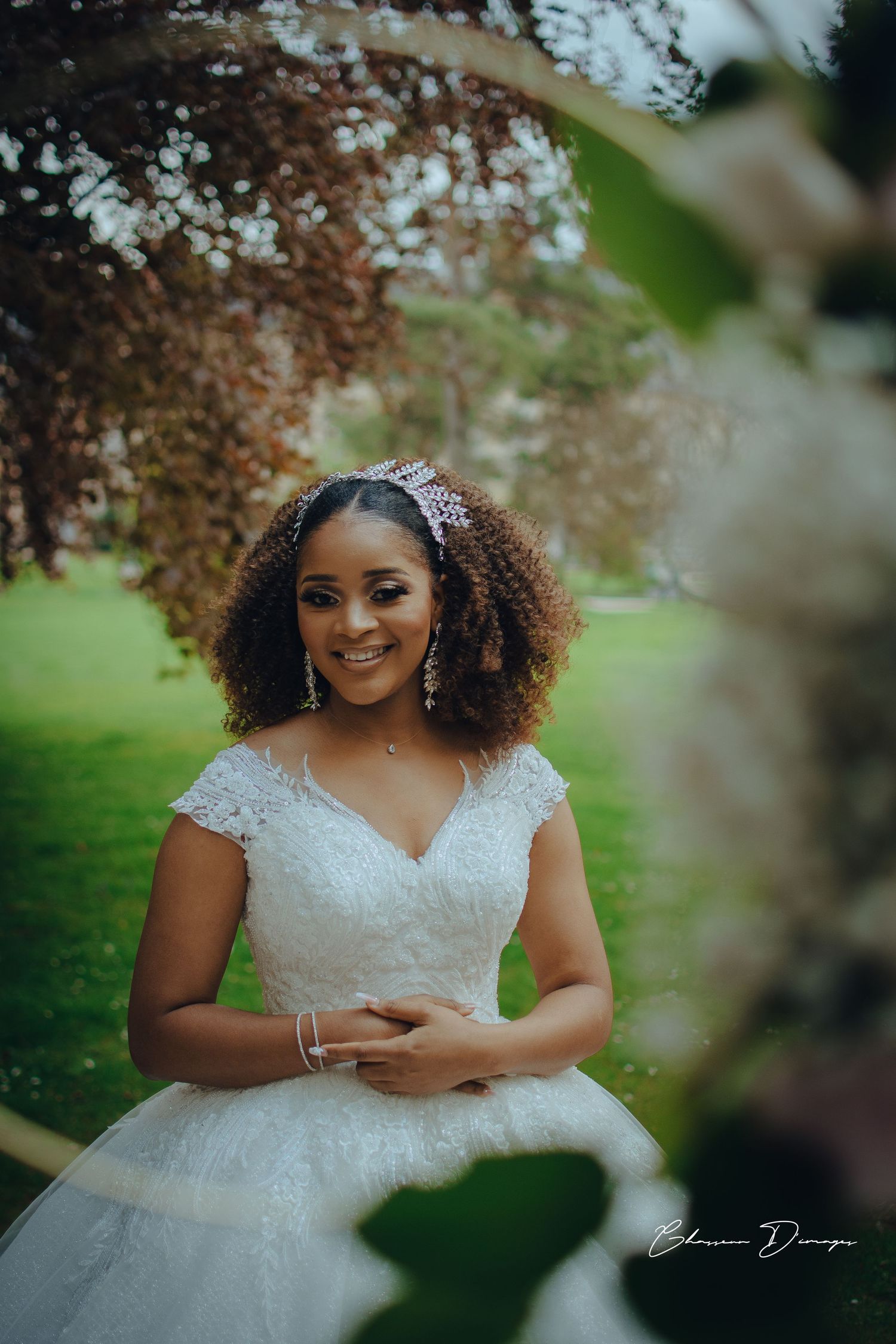 Beautiful bridal portrait showcasing a voluminous white wedding gown and elegant accessories in a garden.
