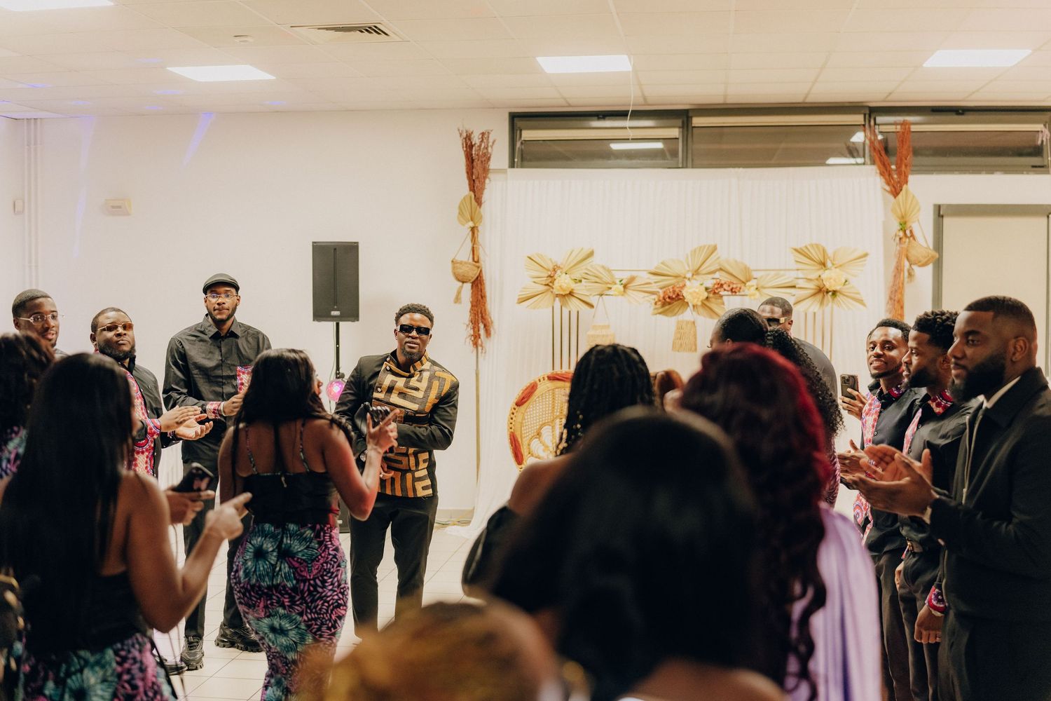 Musicians perform on stage at a wedding reception with decorative gold accents in the background.