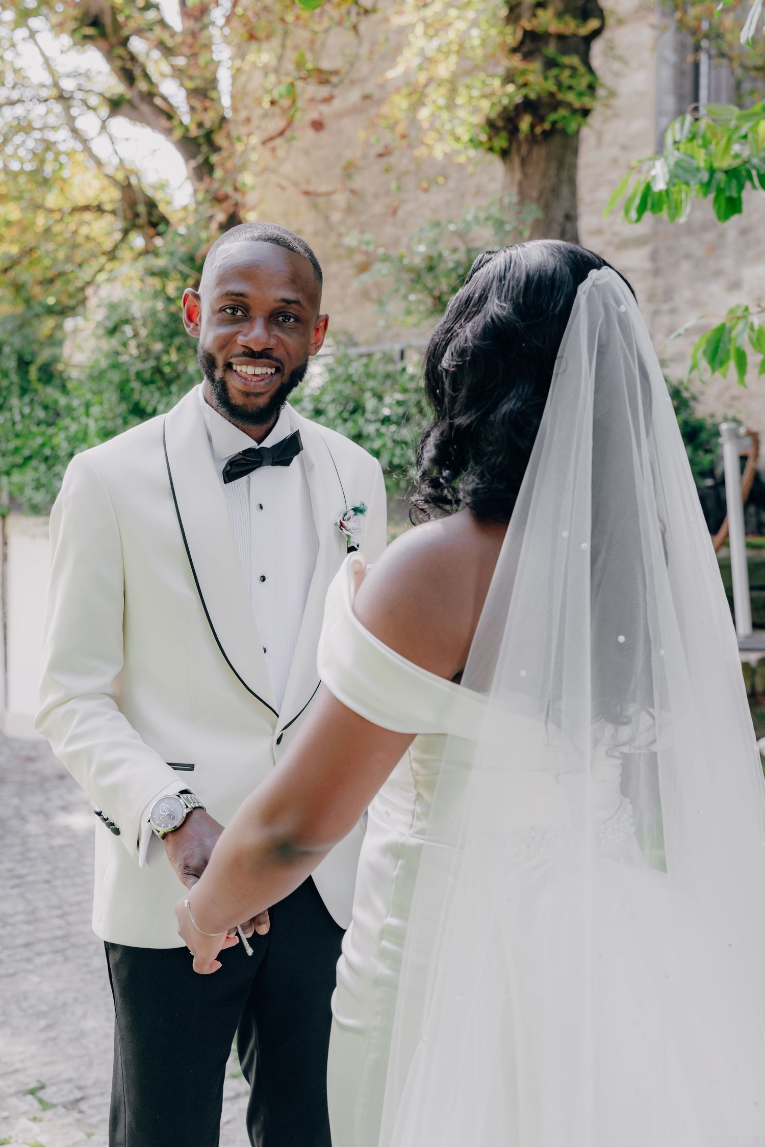 A romantic first look moment between newlyweds with the groom in a white dinner jacket and bow tie.