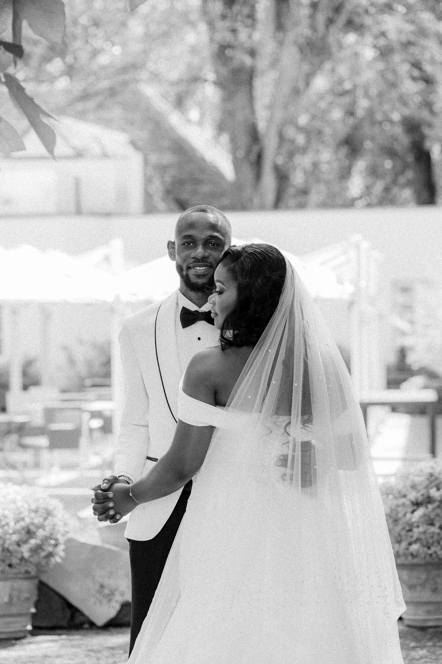 A joyful couple embraces and laughs together during their outdoor wedding photoshoot.