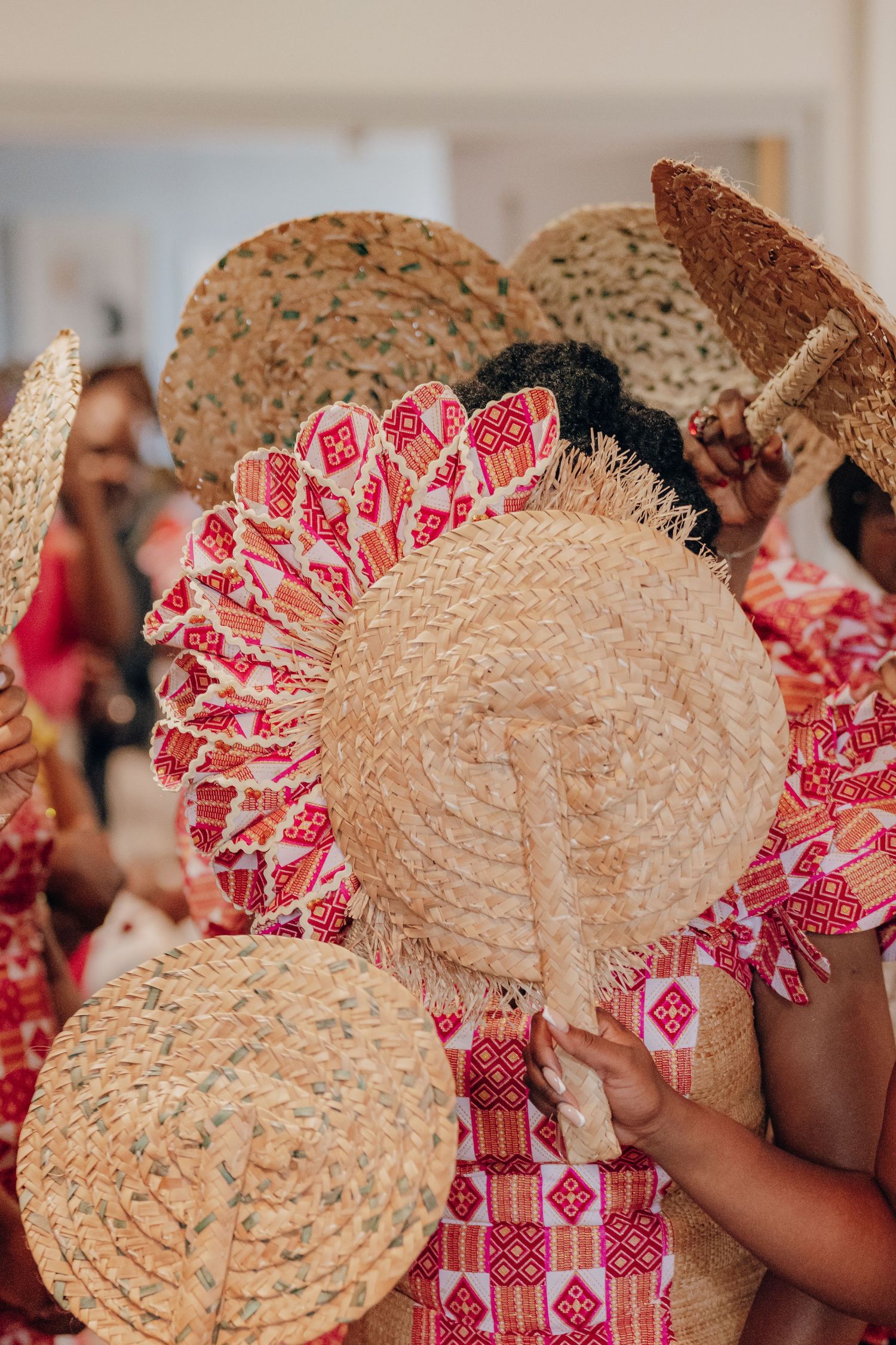 Traditional hand fans in tan and pink patterns arranged in a decorative display at a formal event.