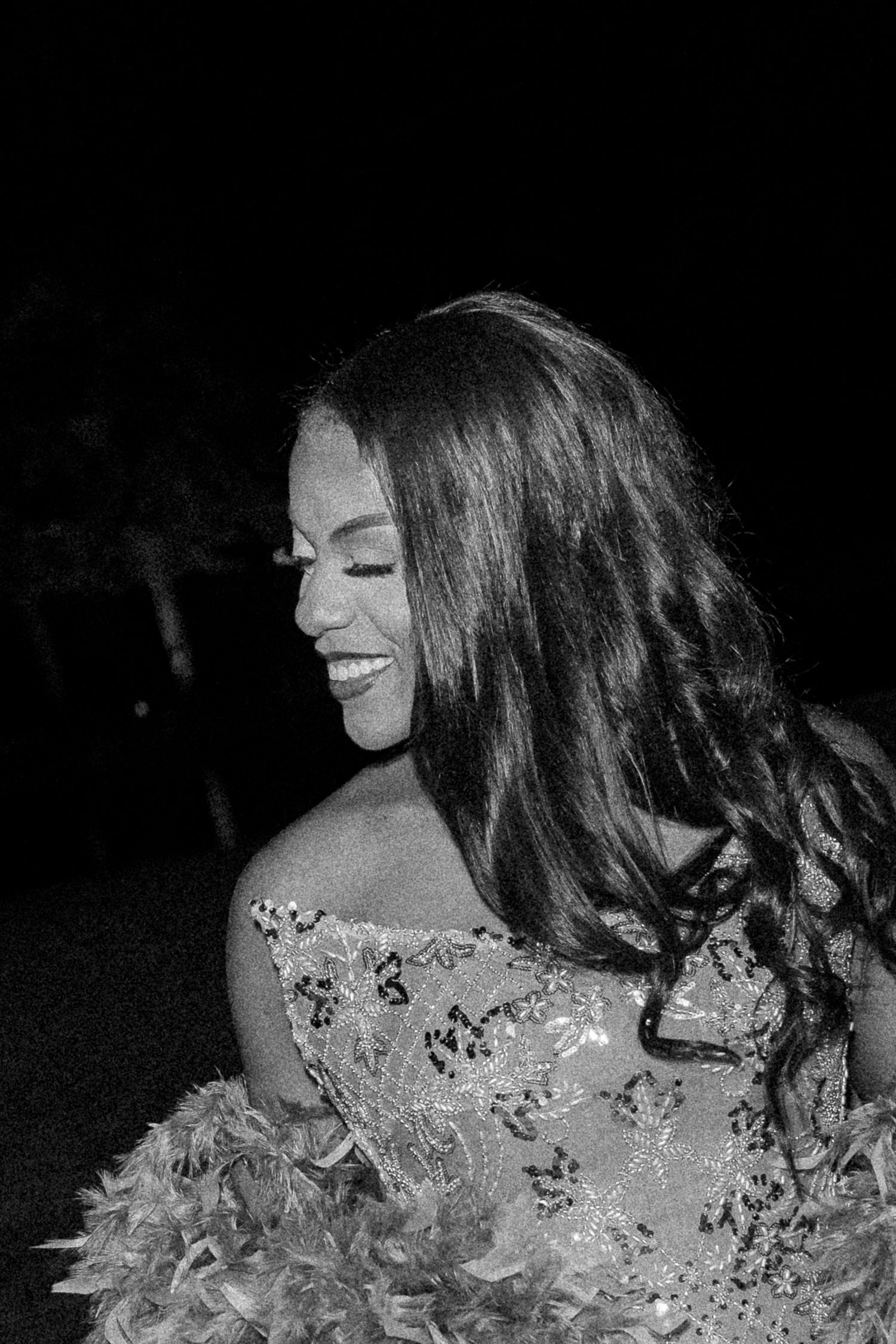 A black and white sequence showing a person with long hair twirling and dancing in a feathered or textured garment.