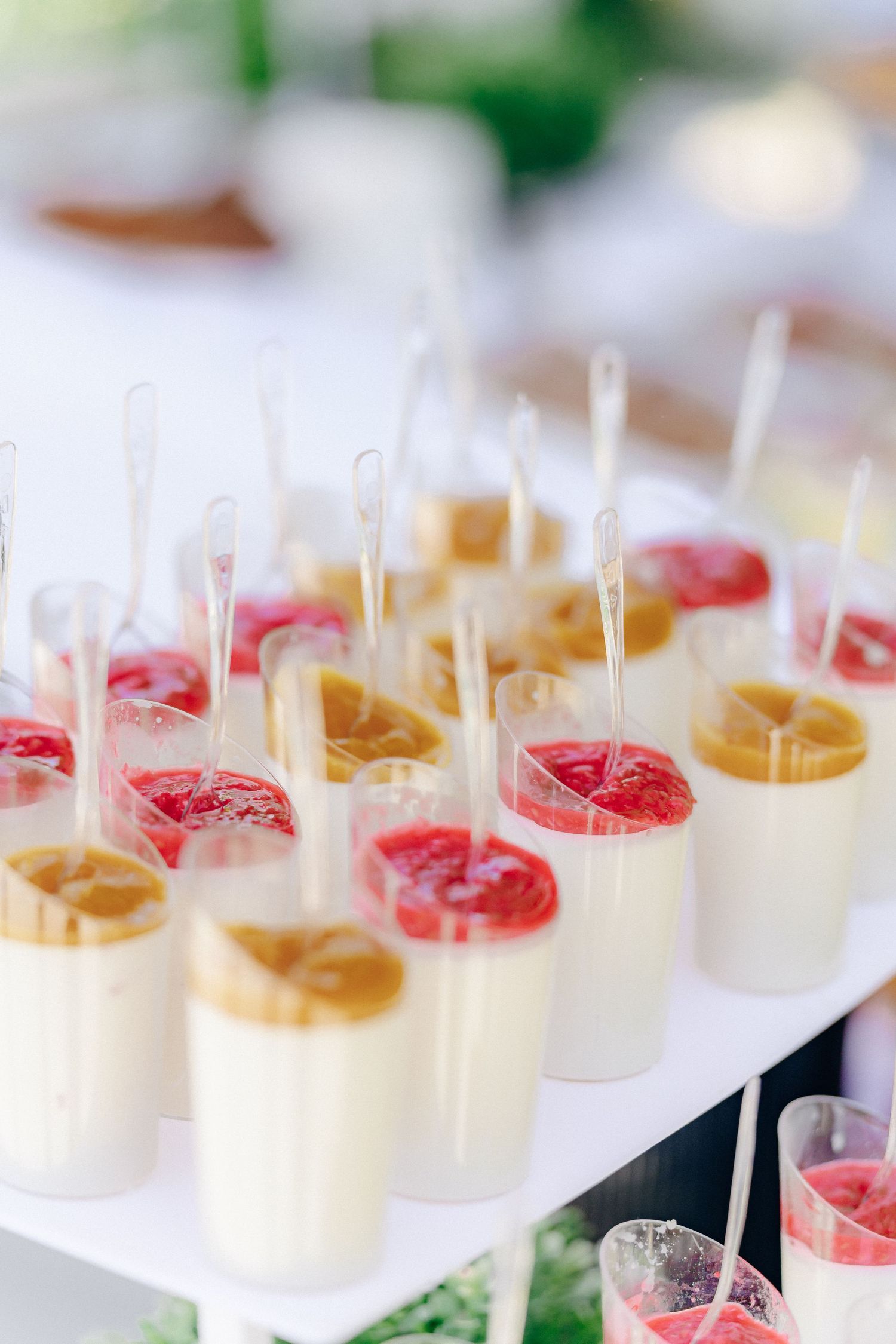Elegant dessert shooters with vanilla panna cotta topped with citrus and grapefruit slices served at a catered event.