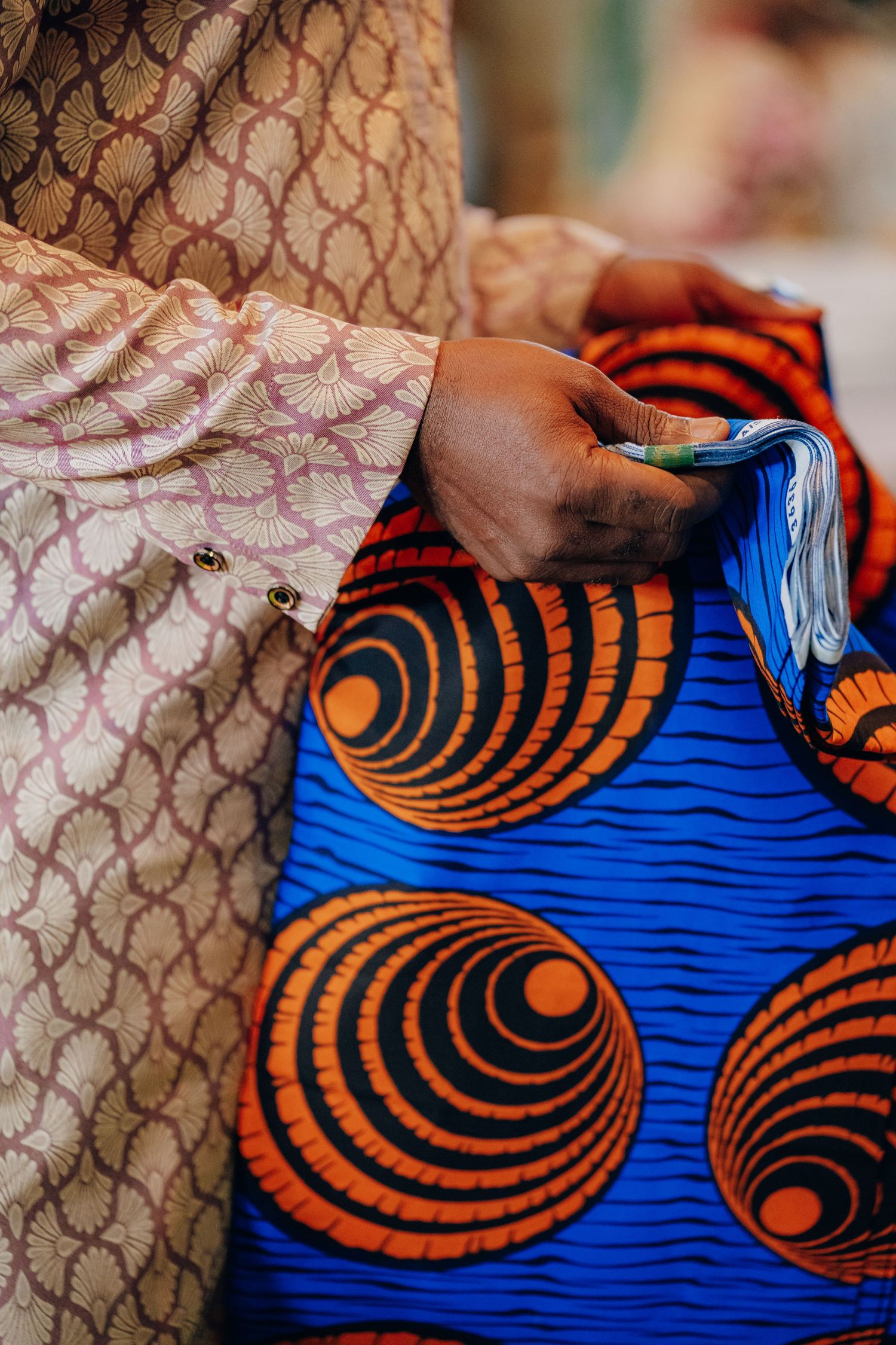 Close-up of vibrant blue and orange African print fabric with circular pattern designs.