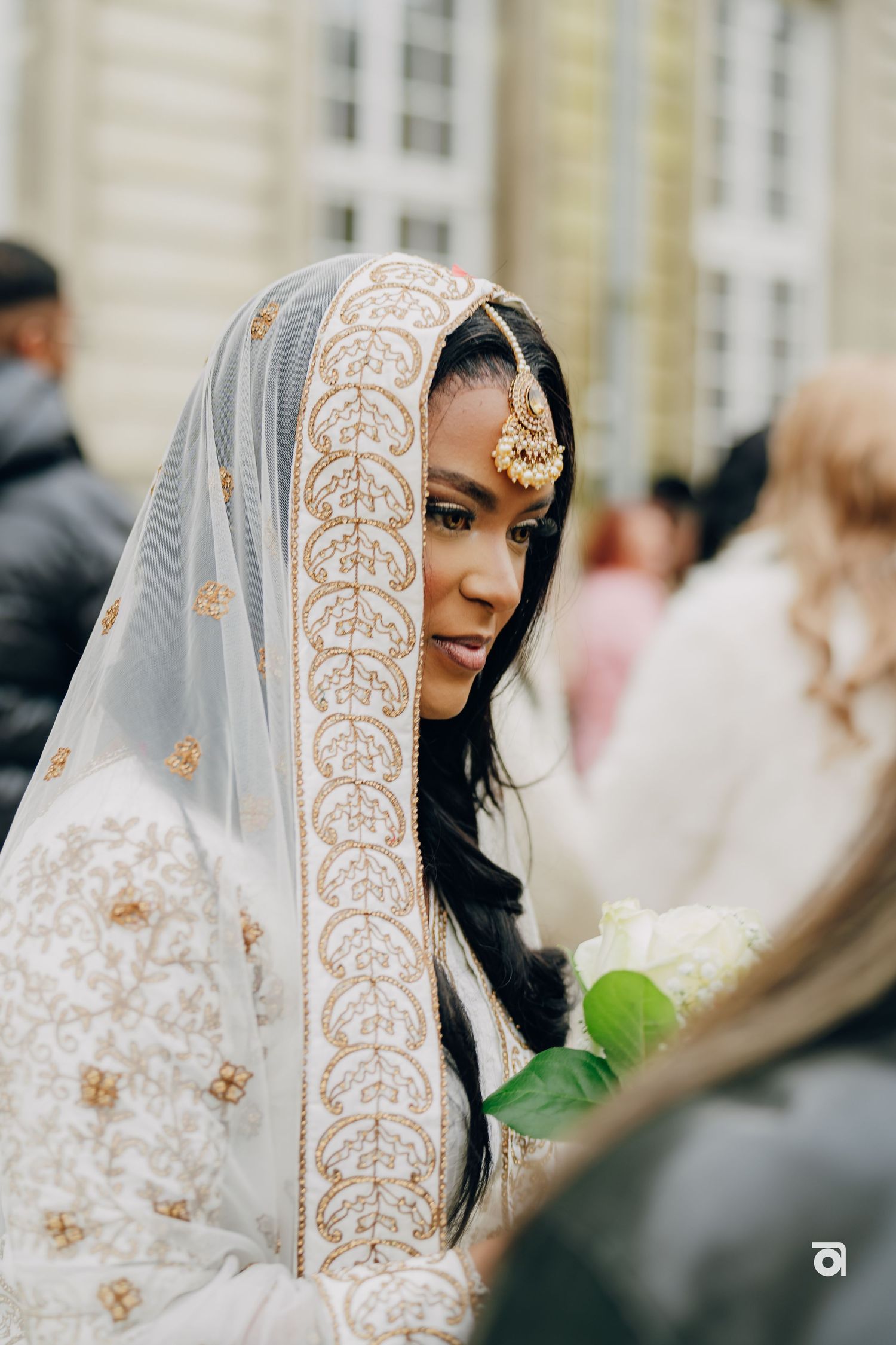 Close-up of intricate bridal details showing embroidered veil and cultural wedding jewelry.