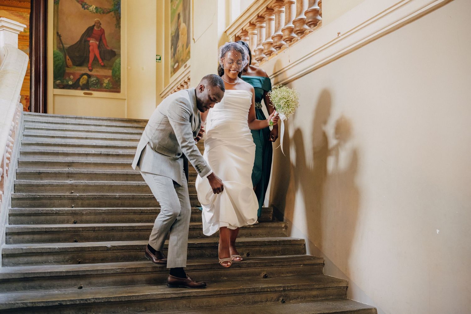 Wedding celebration on an elegant marble staircase inside a historic palace.