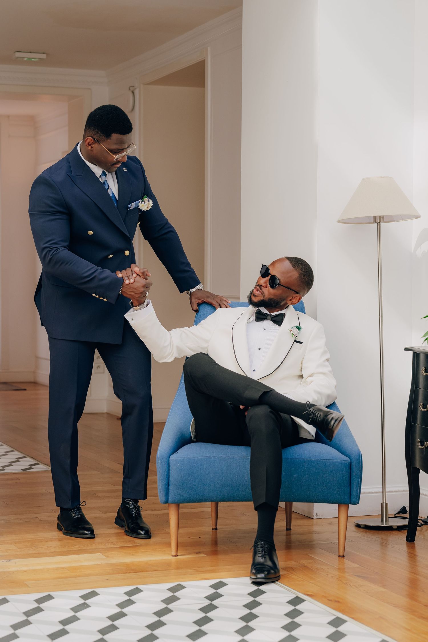Multiple shots of people in formal attire sitting and interacting on blue chairs in a room with hardwood floors.