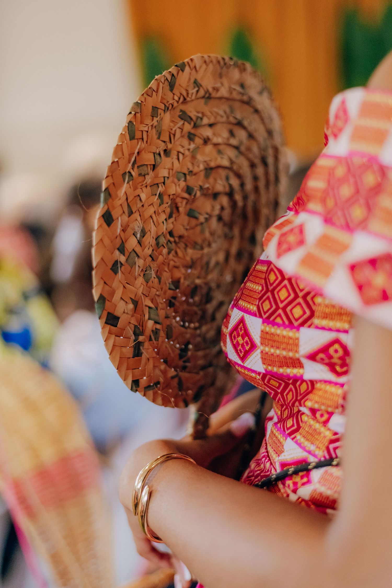 A chocolate ice cream cone with colorful patterned napkin wrapper being held against a blurred background.