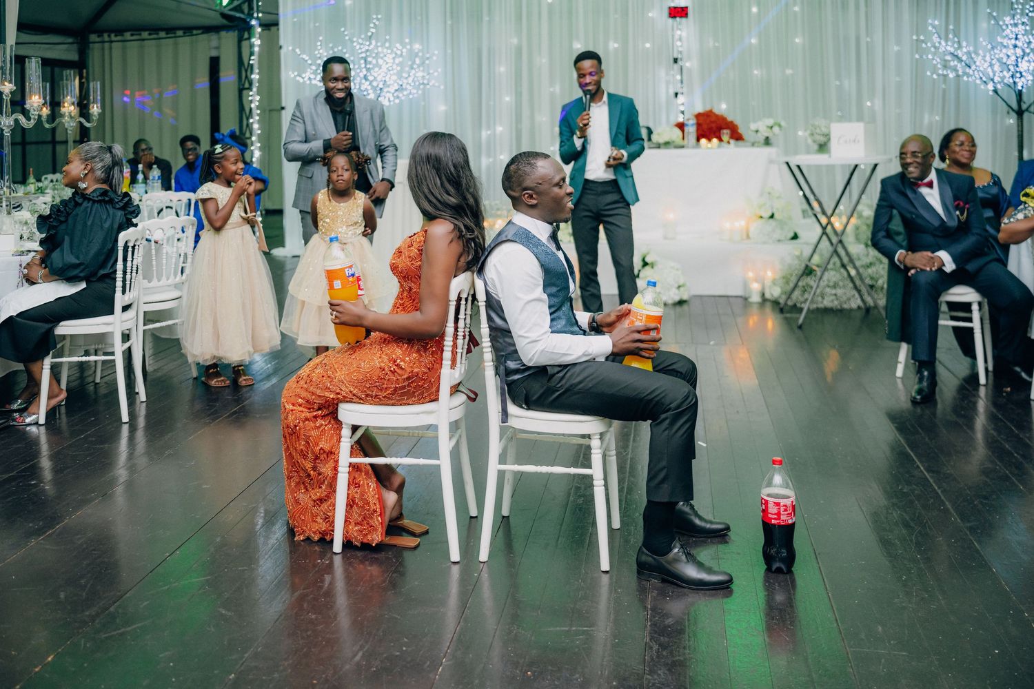 Wedding reception venue with white chairs and elegant decor setup.
