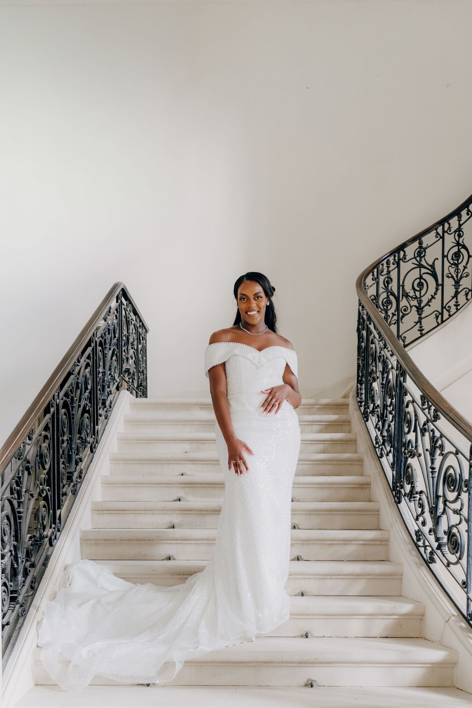A series of elegant bridal portraits showing someone in a white wedding dress descending marble stairs with ornate railings.