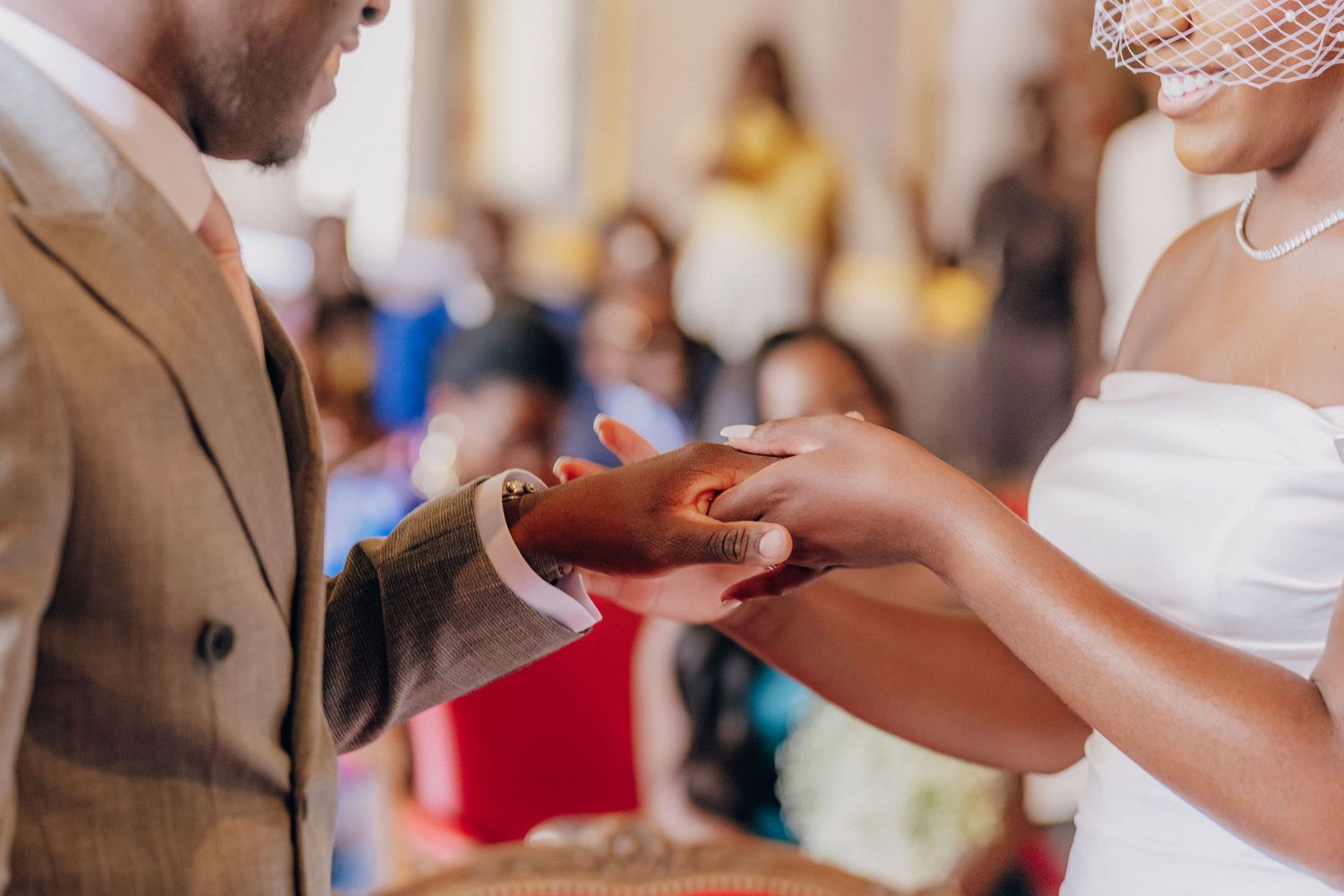 Close-up view of hands exchanging wedding rings during a ceremony.