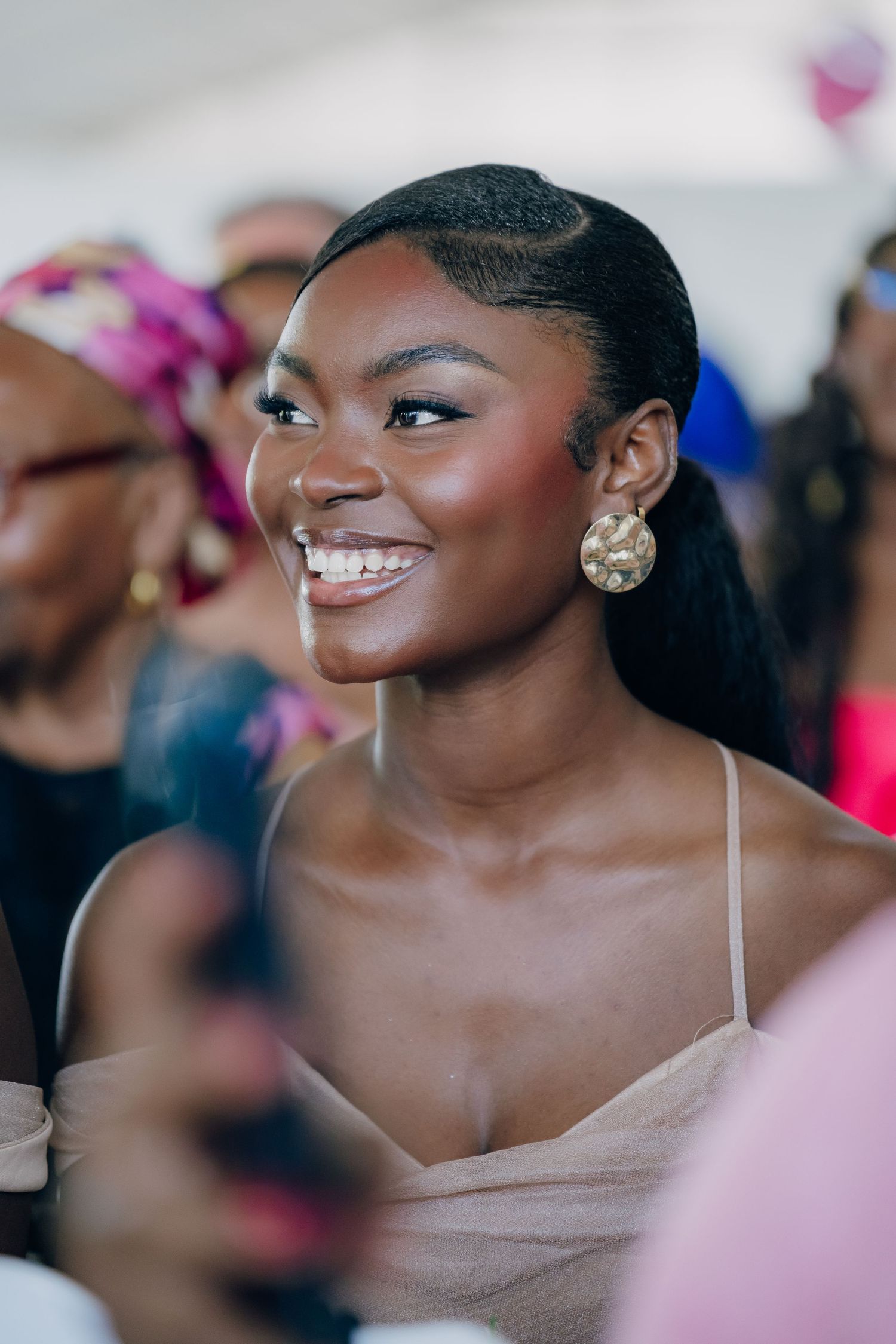 Close-up portraits showing radiant smiles and elegant makeup at a formal event.