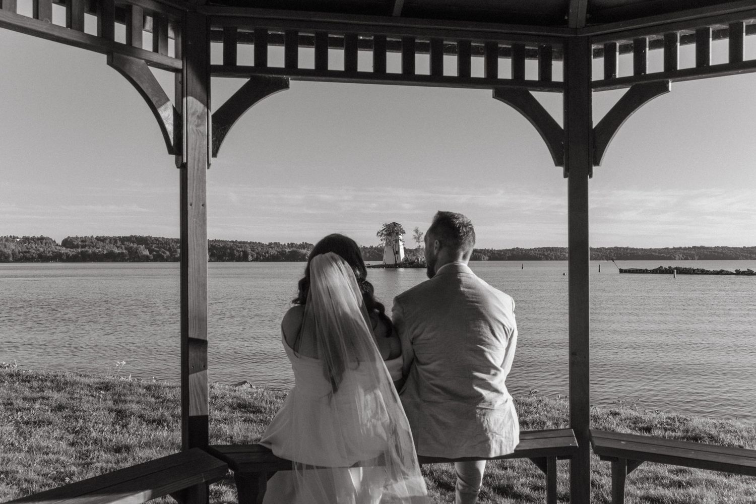 A black and white panoramic series of coastal views through a gazebo or covered porch overlooking the ocean and beach.