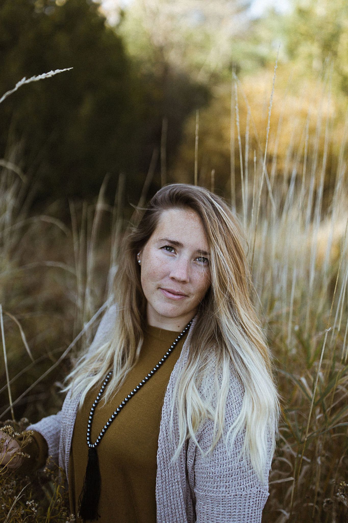 Close up portrait of woman with blonde hair against blurred natural background.
