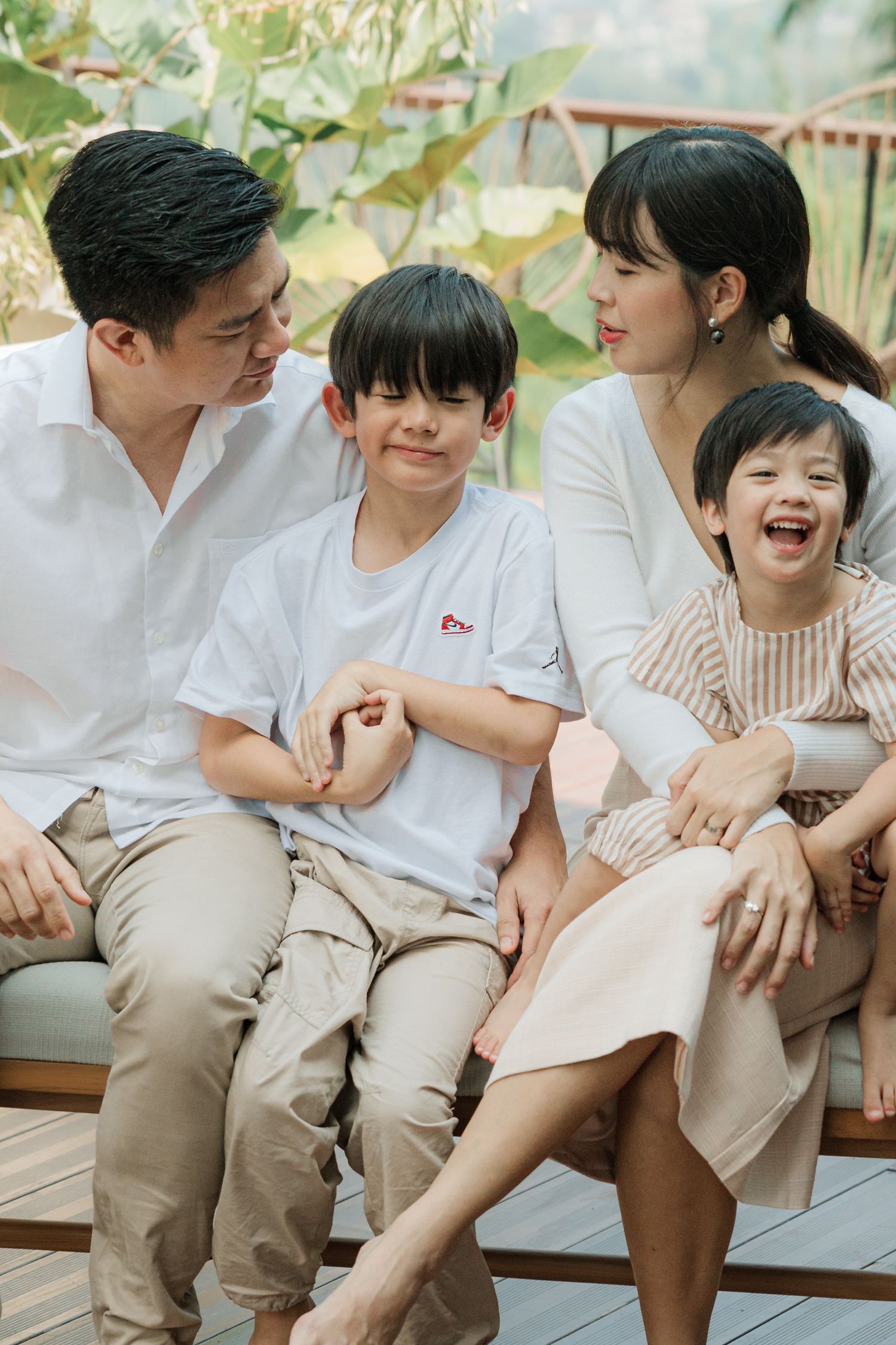 Family sharing joyful moment together on outdoor bench.