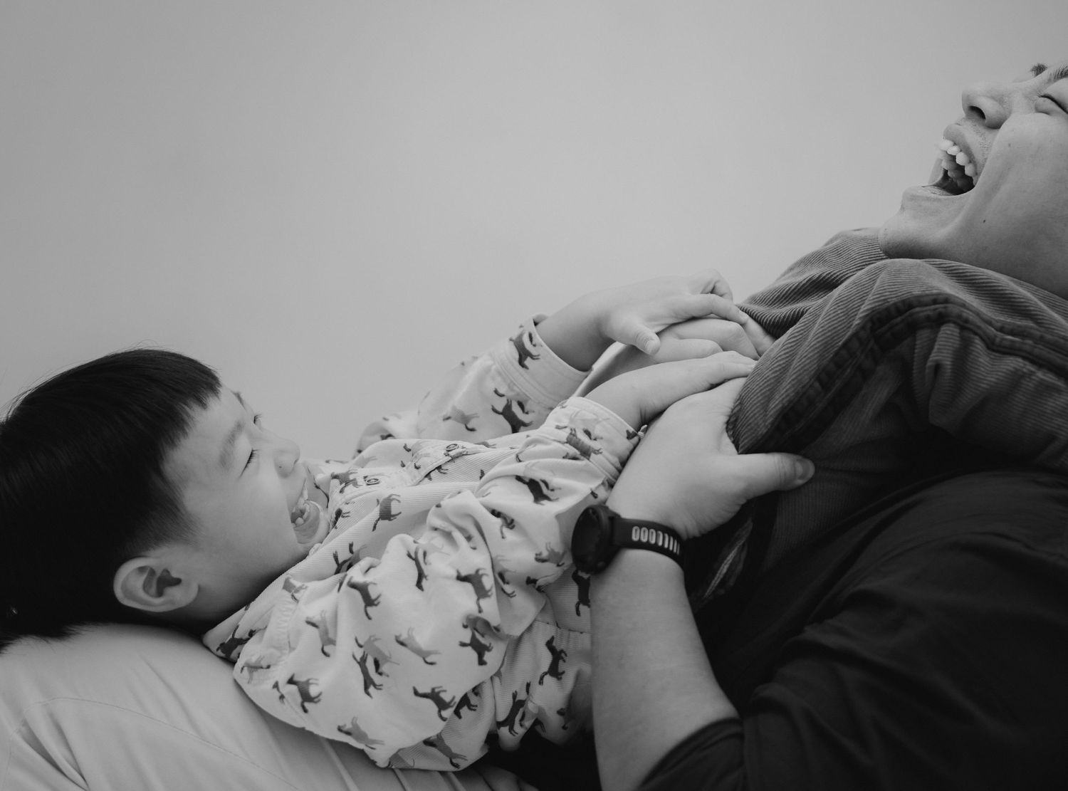 A tender black and white moment of parent and child resting together.