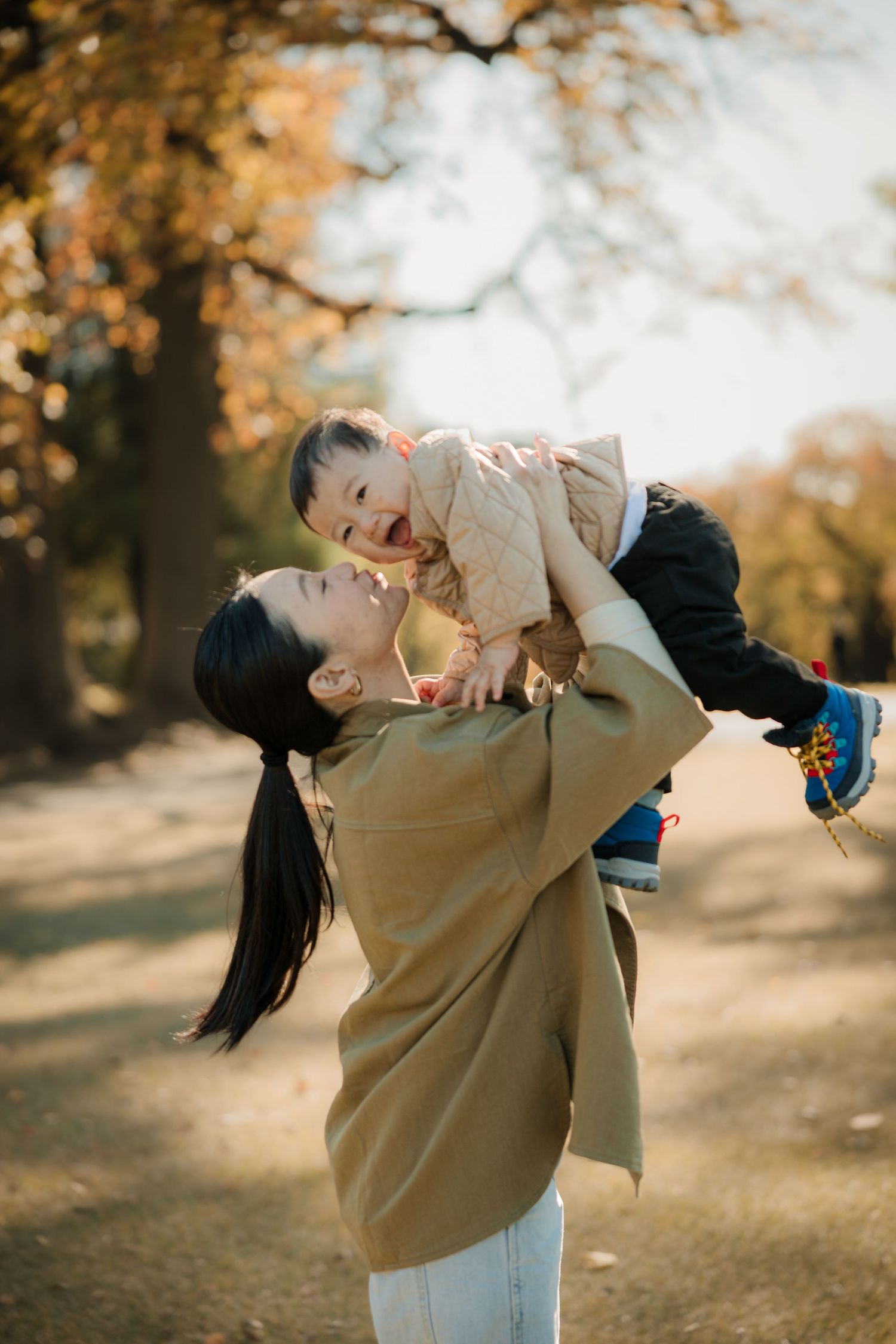 Playful moment between parent and child in autumn setting.