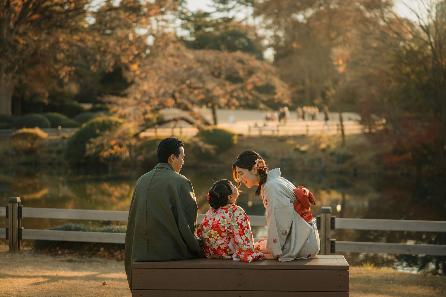 Couple sitting on bench overlooking autumn garden scenery.