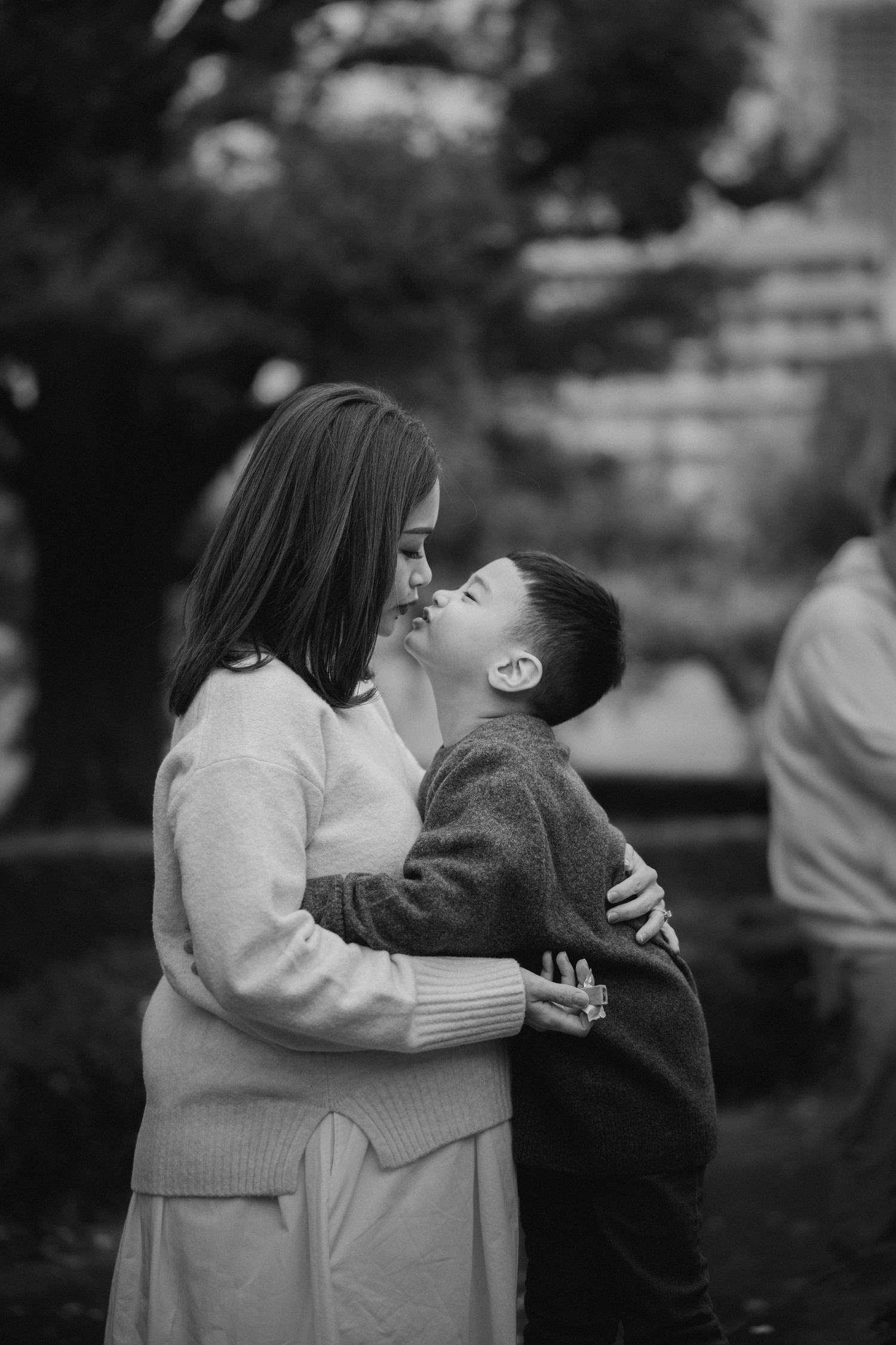 Sweet moment captured in black and white between parent and child outdoors.