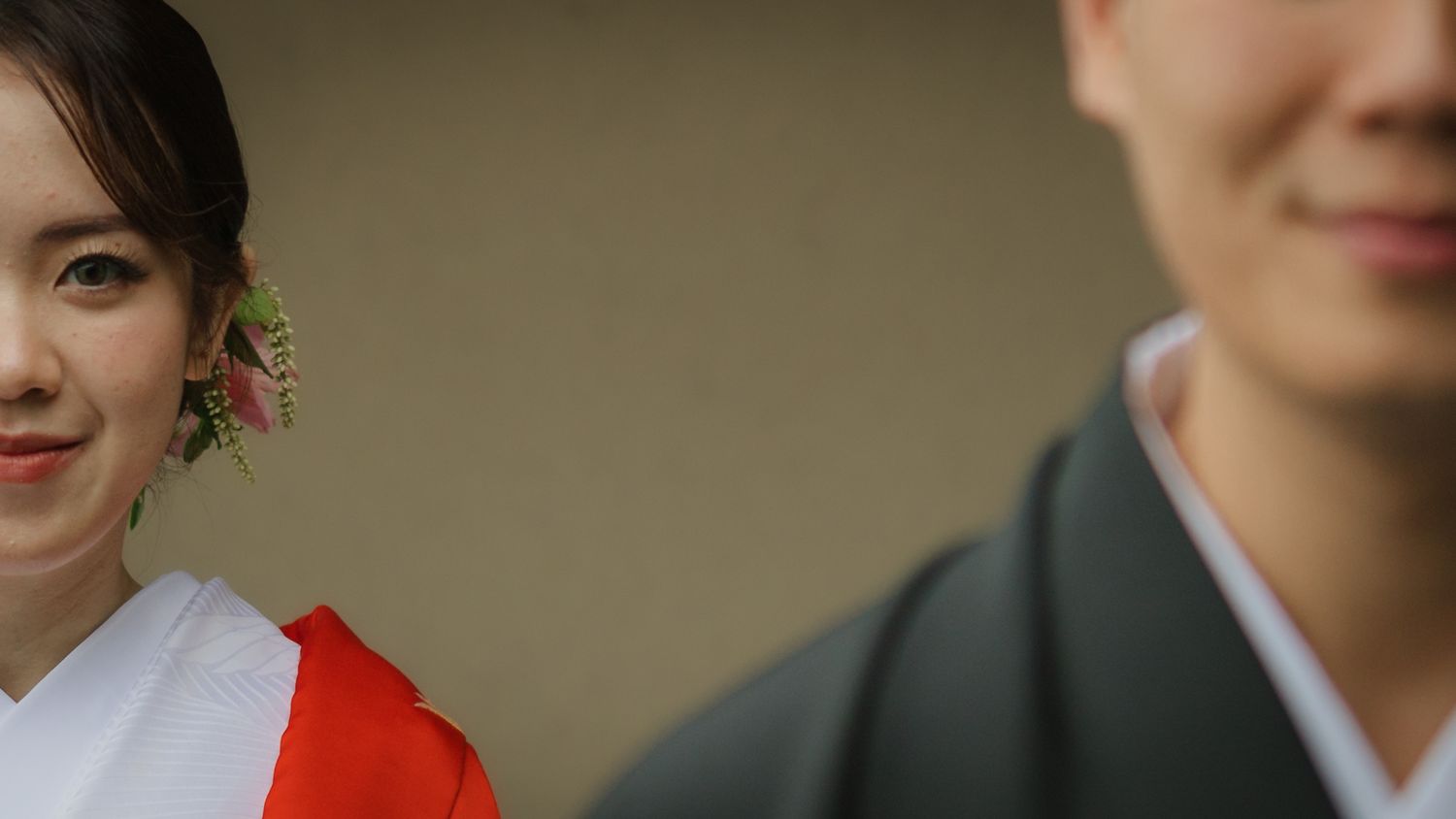 Close-up shot of a couple in traditional wedding attire, with white kimono and green accents visible.